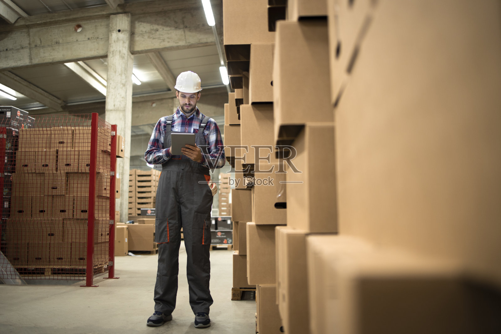 仓储主管手持平板电脑，组织从仓库到零售市场的货物配送和发运。照片摄影图片