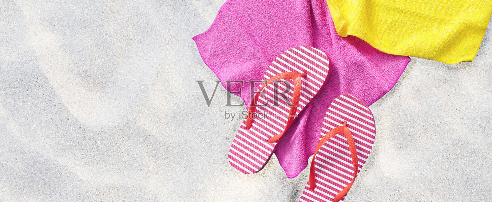 沙滩纹理背景。还有夏天的配饰拖鞋和毛巾。模拟和复制空间。前视图。有选择性的重点。照片摄影图片