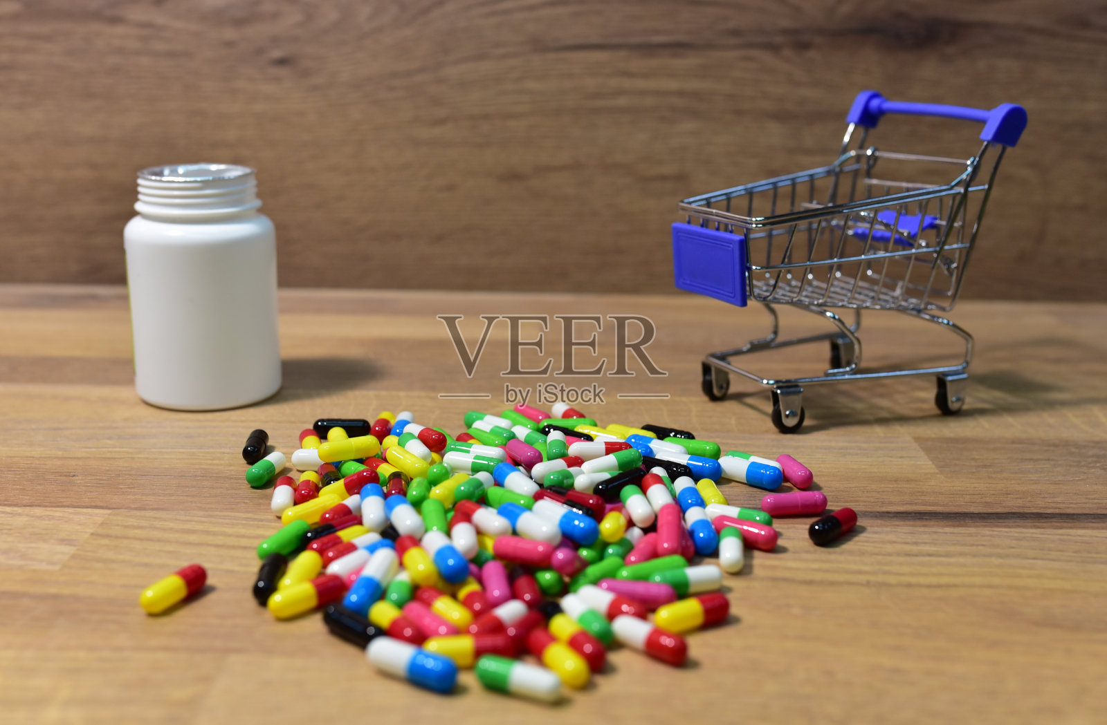 木材背景下的购物篮里的药丸。把钱花在药品和药丸上的经济观念照片摄影图片