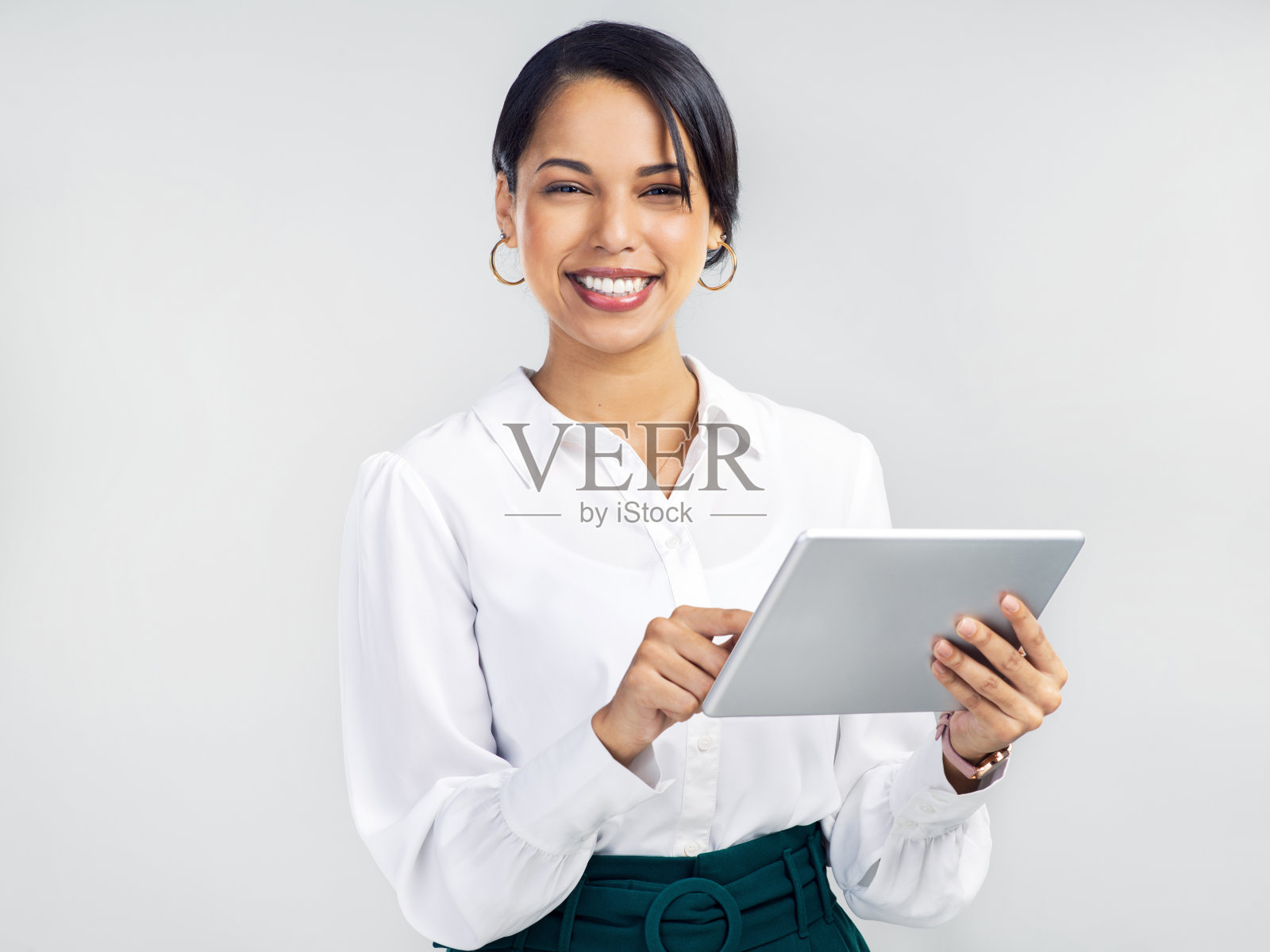 一名年轻女商人在灰色背景下使用数码平板电脑照片摄影图片