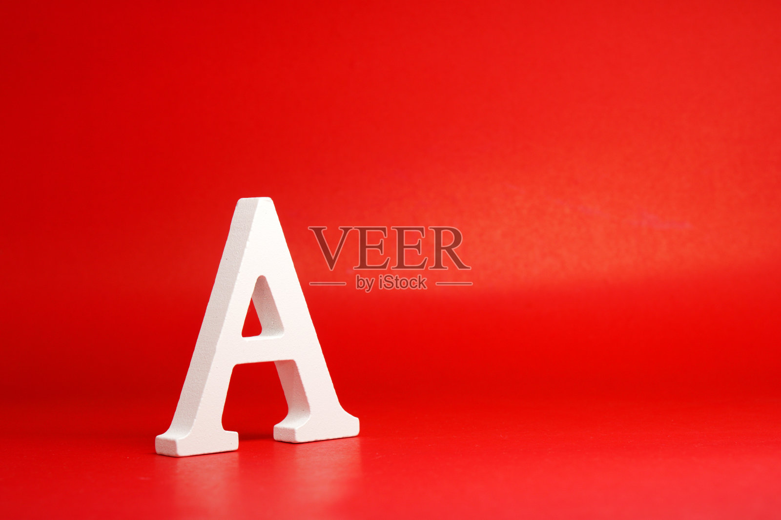 一个白色字母单词木制孤立红色背景与复制空间-广告对象符号或最佳等级竞争概念照片摄影图片