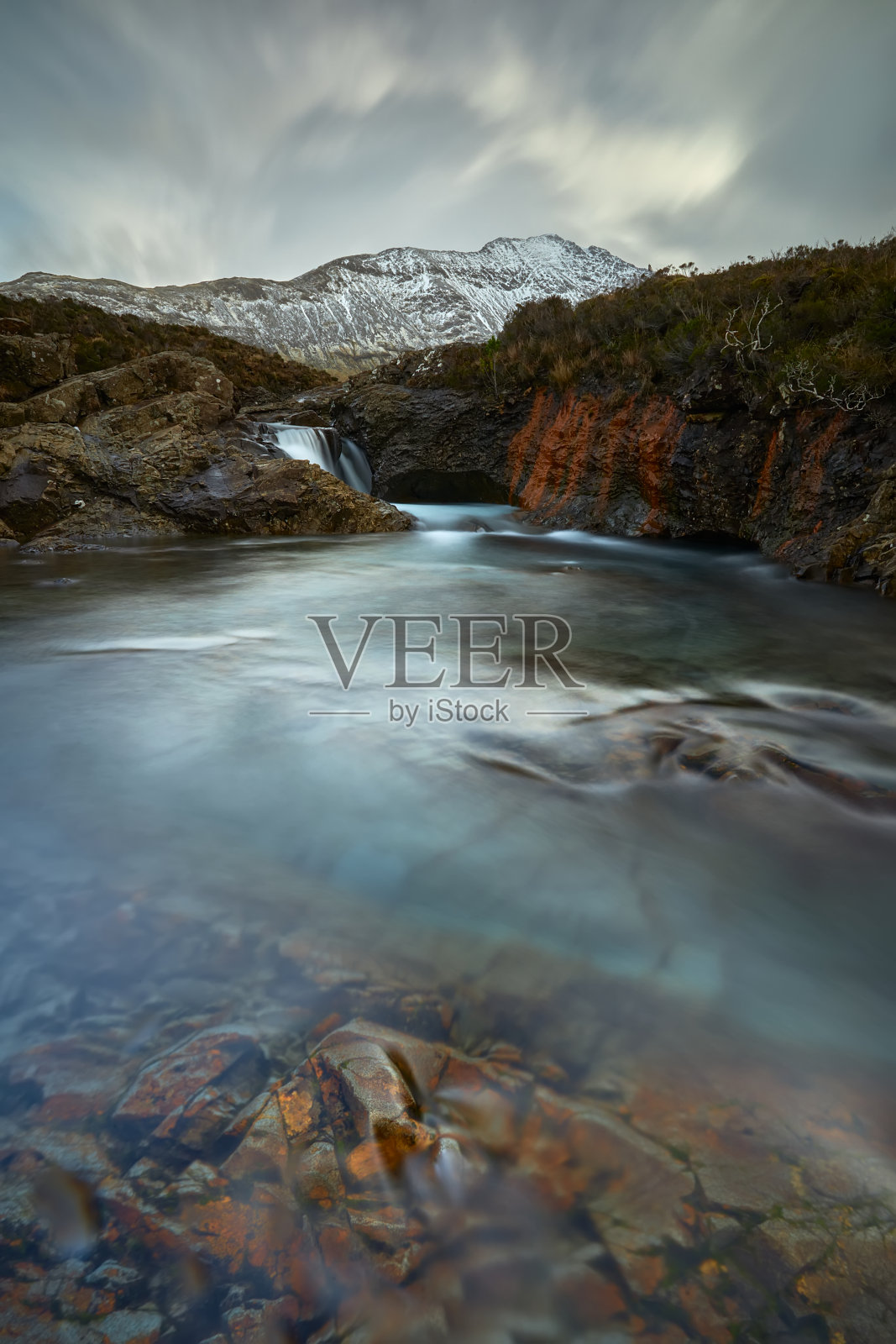 绿松石和透明的水与岩石和丝绸般的水。红色的悬崖和冬天的山-精灵池-斯凯岛-苏格兰-英国照片摄影图片