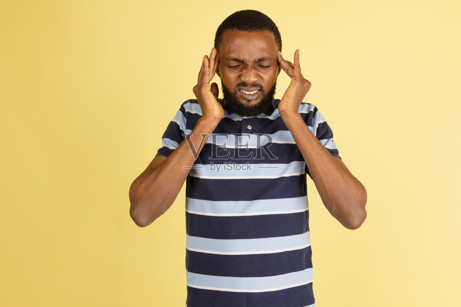 一个非洲年轻人孤立地摆着姿势，在黄色的演播室背景下拍摄广告照片摄影图片