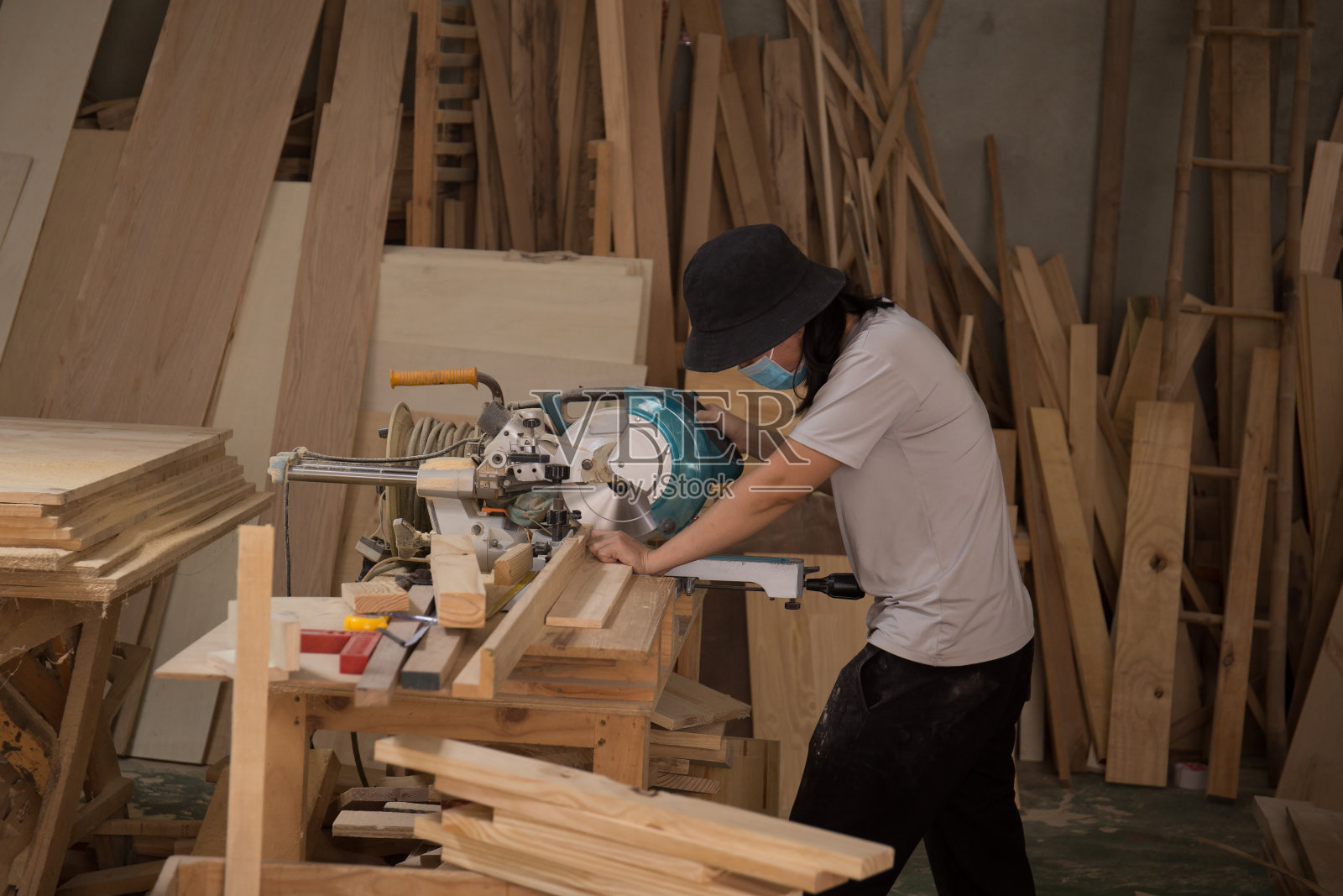 在车间用电动圆锯加工木材的木匠。木制家具的细木工工作。中小企业的概念照片摄影图片