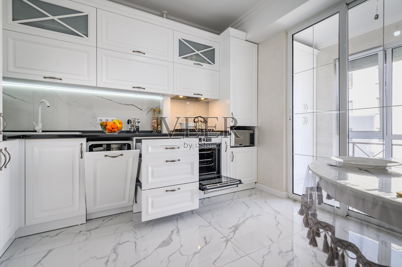 豪华的白色现代厨房内饰，抽屉拉开，洗碗机门打开照片摄影图片