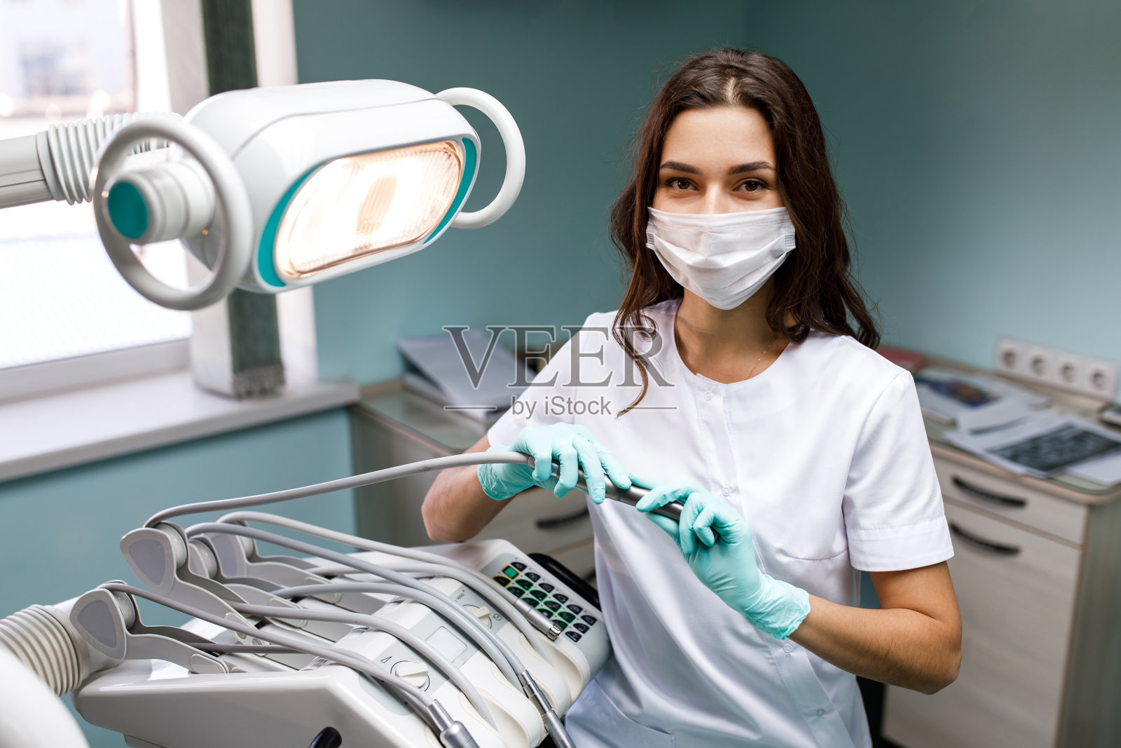 一个美丽快乐的年轻女医生在医疗牙医中心的形象。在工作场所穿着白大褂的年轻女牙医照片摄影图片