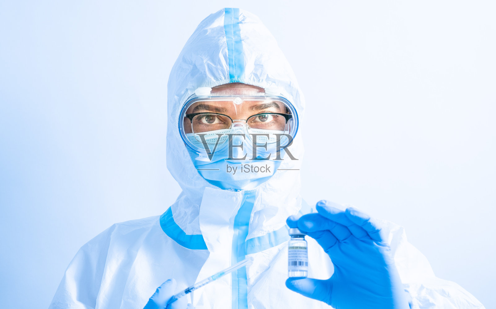 女医生、科学家或护士佩戴个人防护用品口罩及生物危害防护服肖像。新冠肺炎疫情警报。女护士穿着医疗制服和护目镜。照片摄影图片