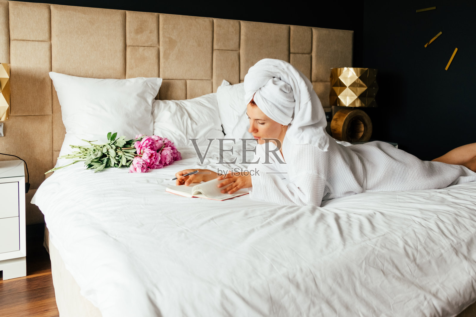 女人把事情记在笔记本上。照片摄影图片