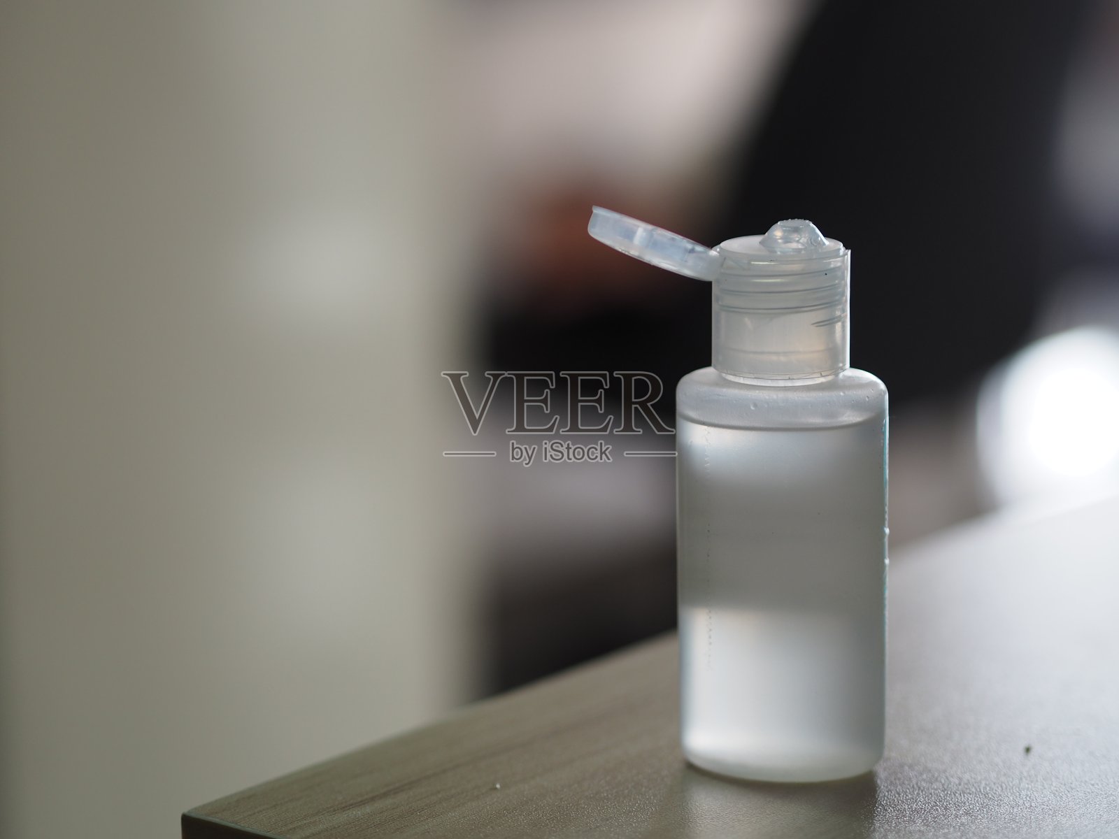洗手液、凝胶酒精混合物和明胶在透明塑料瓶中，用泵推洗干净，防止细菌感染，保护传染性疾病冠状病毒covid-19，在桌子上模糊的背景照片摄影图片