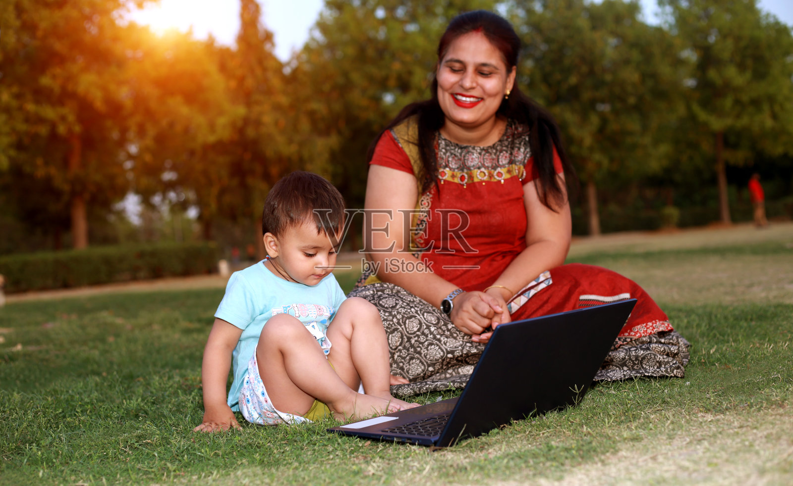 母亲和婴儿使用笔记本电脑照片摄影图片
