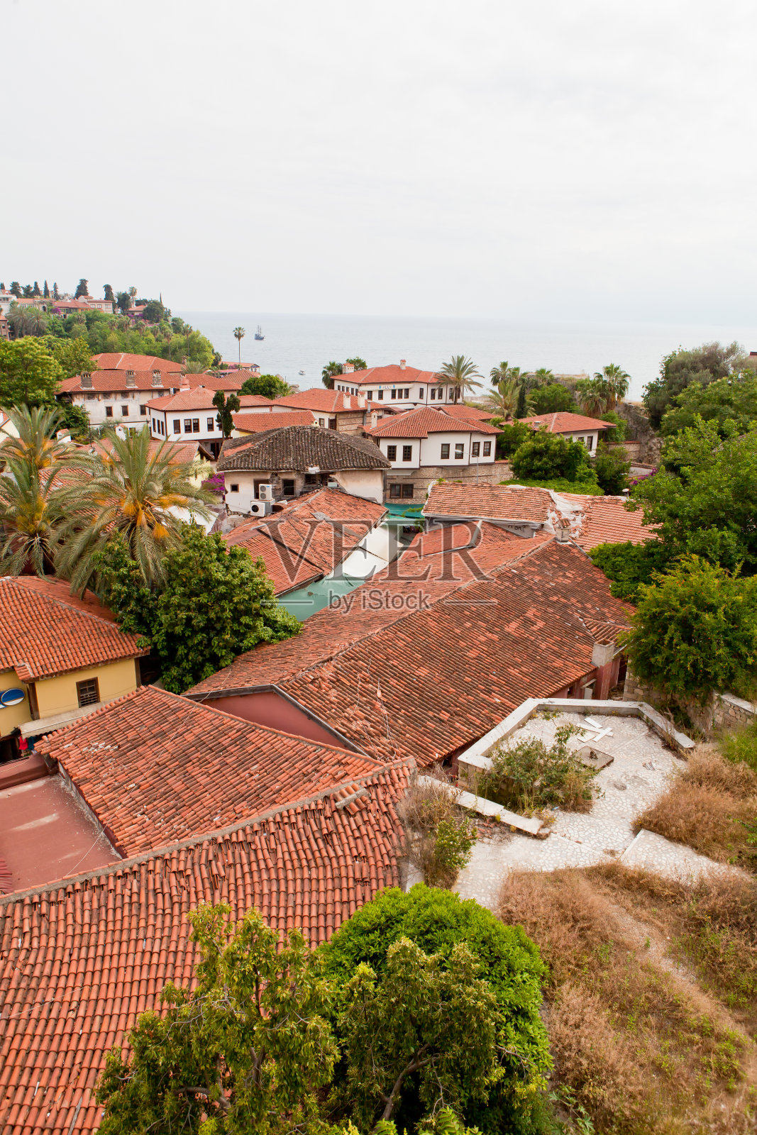 透过城市的红色屋顶，可以看到海景照片摄影图片