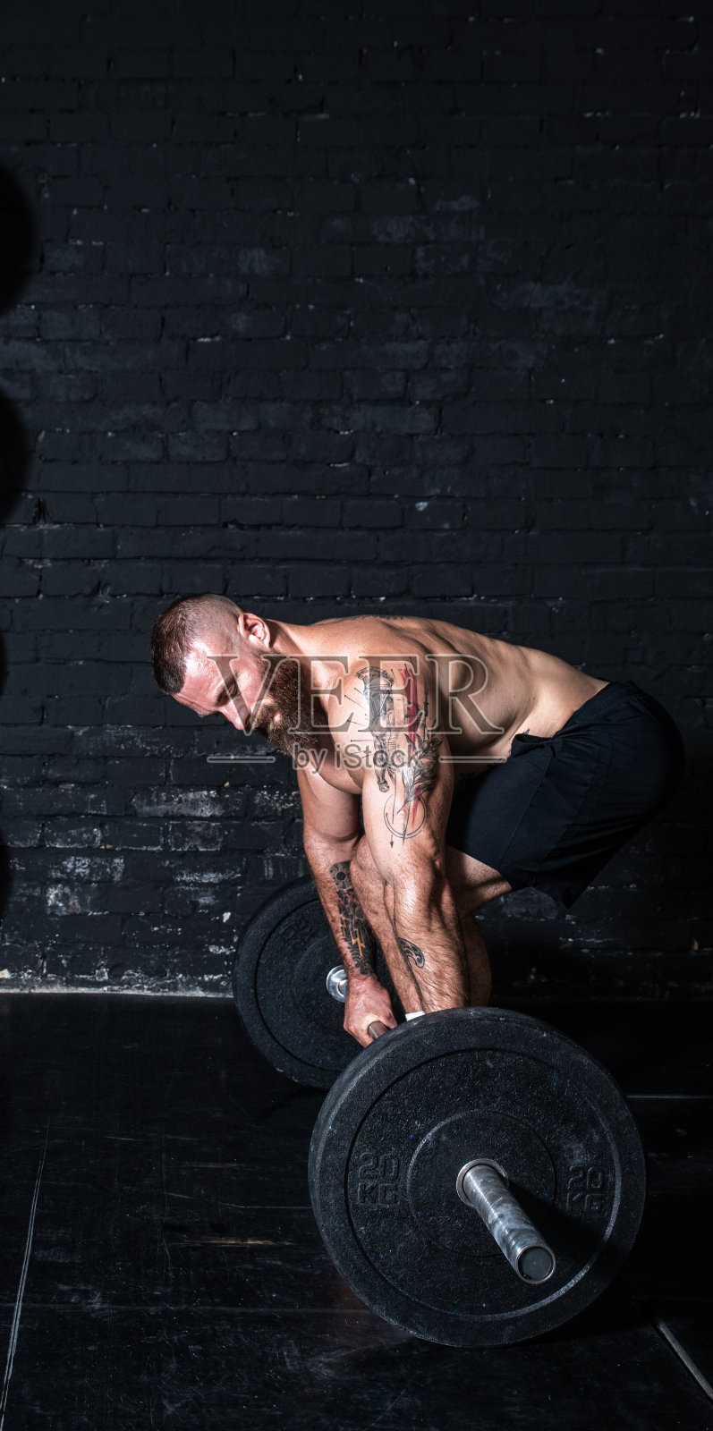 年轻活跃强壮健美肌肉出汗的男人与大肌肉做杠铃重量死举硬核交叉训练锻炼在健身房黑暗的形象真实的人锻炼照片摄影图片