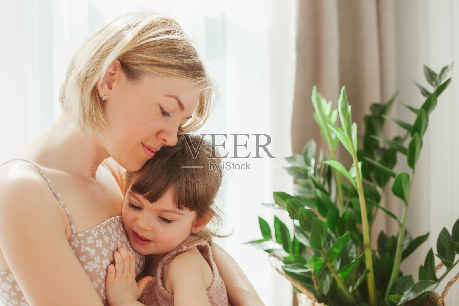 小女孩和她妈妈拥抱在一起照片摄影图片