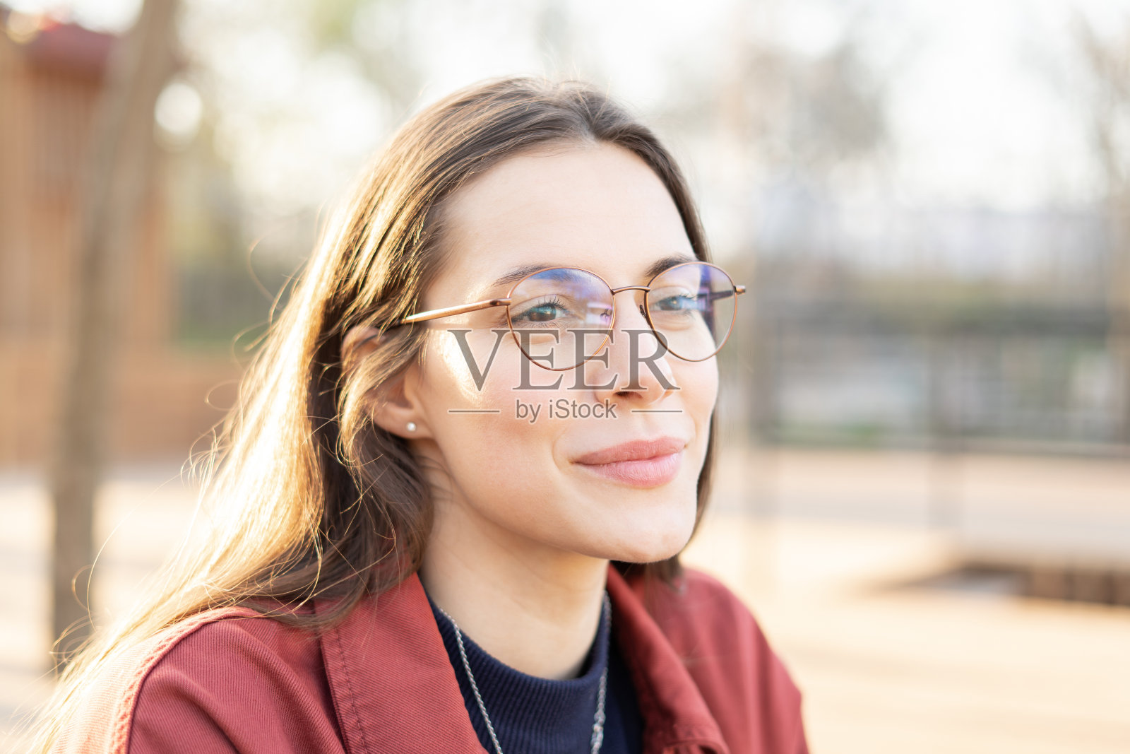 一个迷人的中年妇女的近距离肖像戴着完美的皮肤和黑发眼镜在日落的外面照片摄影图片