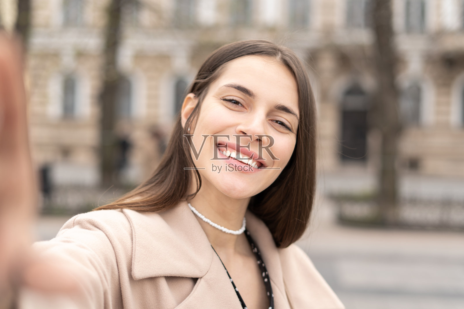 一个迷人的商业女人的肖像与一个大大的微笑站在公园自拍照片摄影图片