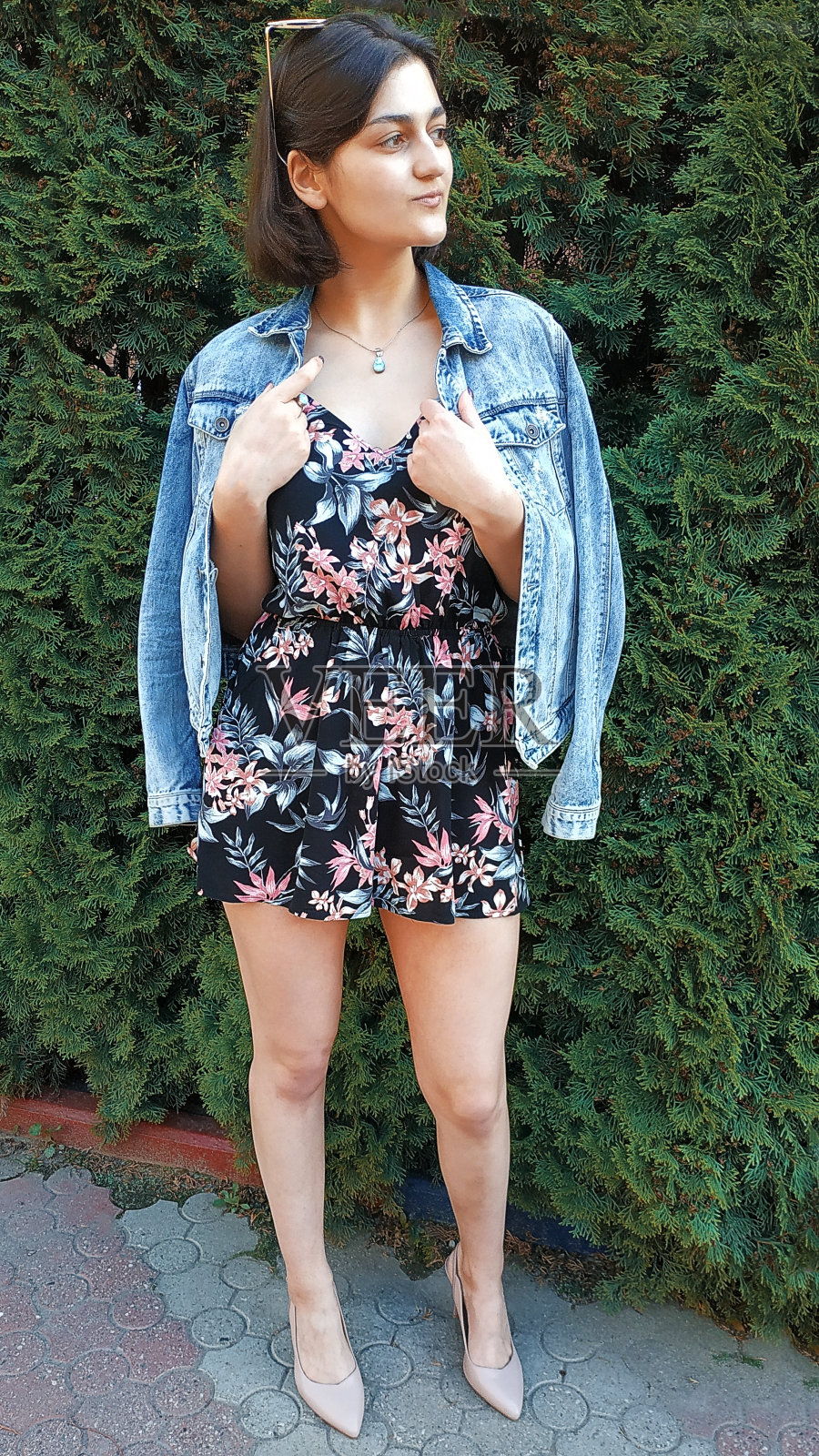 一个穿着黑色裙子和牛仔夹克，外表像白人的女孩。一个黑发。照片摄影图片