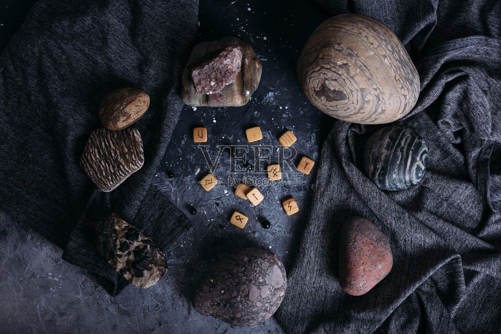 石头间的木头符文占卜。阴沉神秘的女巫桌。照片摄影图片