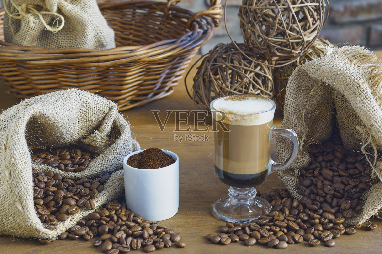 一杯新鲜的咖啡，周围是咖啡豆和一些磨碎的咖啡。照片摄影图片