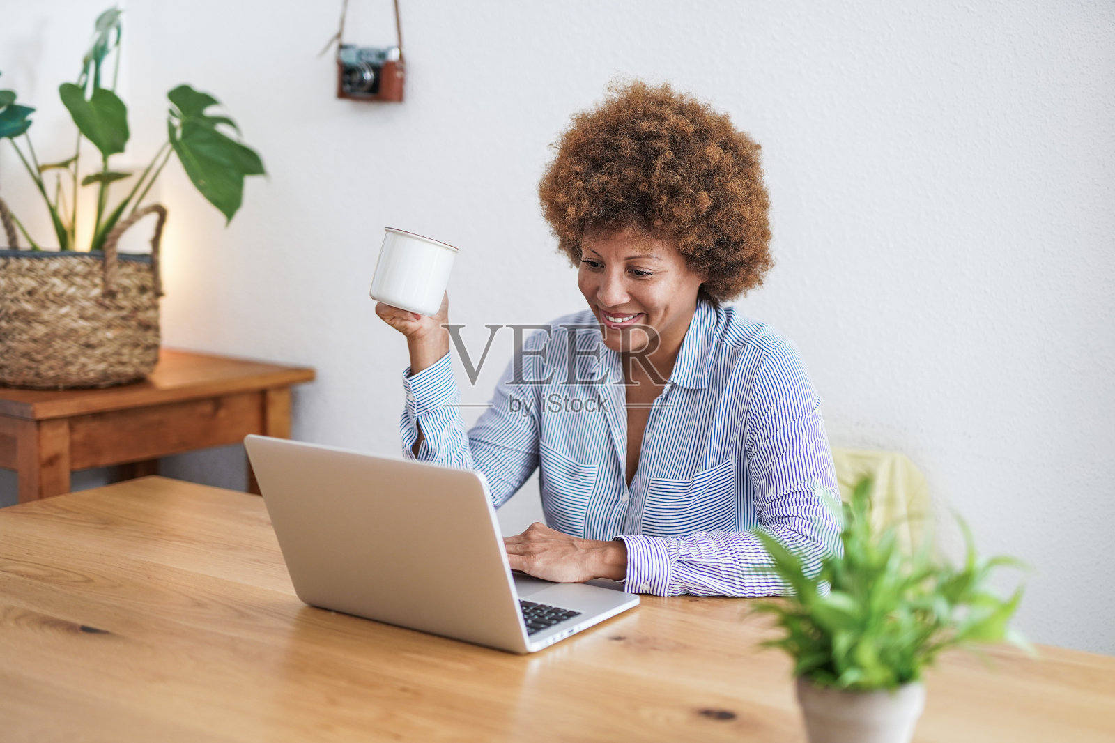 成熟的非洲妇女在家工作与电脑笔记本电脑-快乐的老人和技术概念照片摄影图片