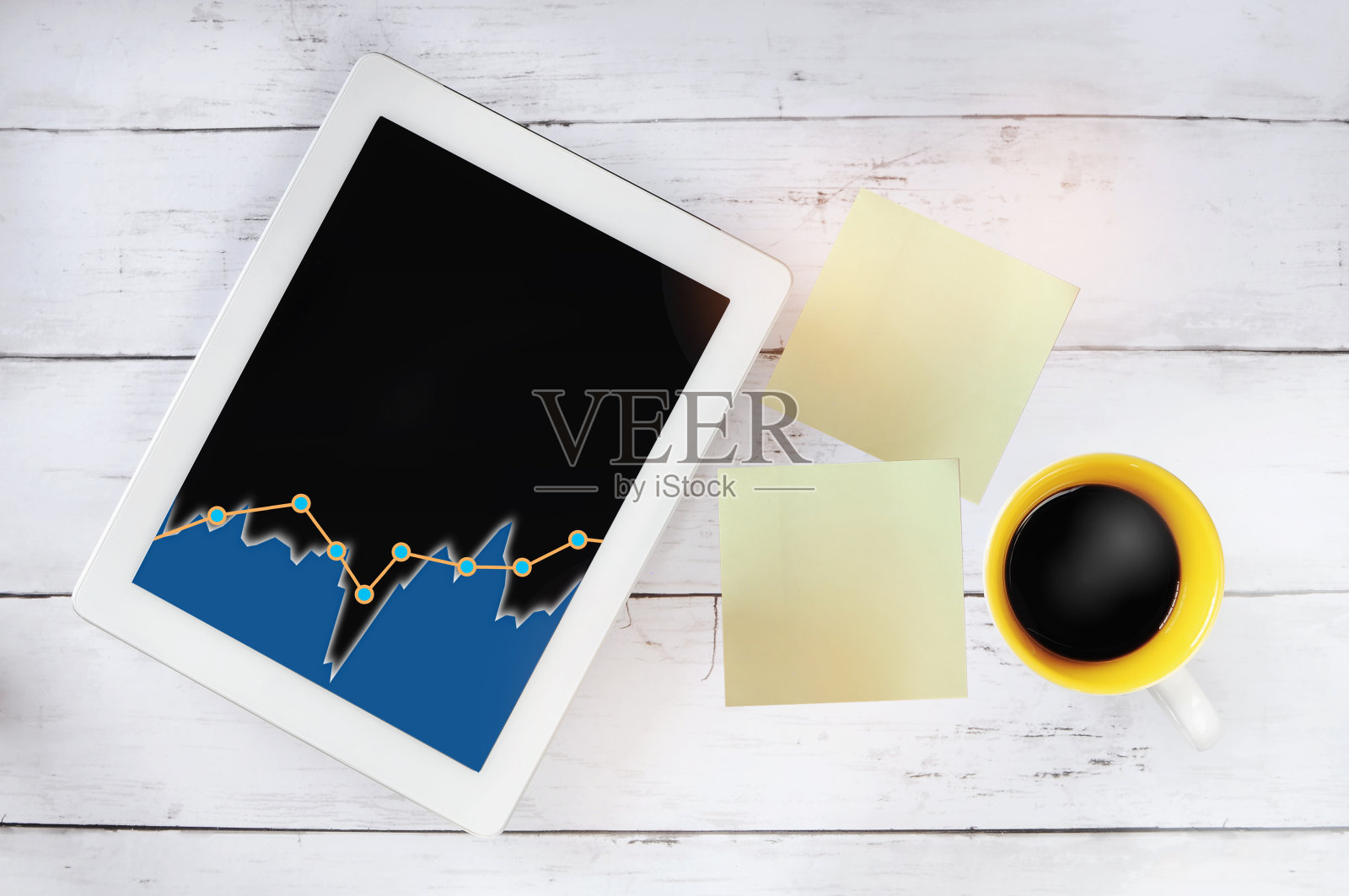 平板电脑上的增长图，桌上放着一杯咖啡和便利贴照片摄影图片