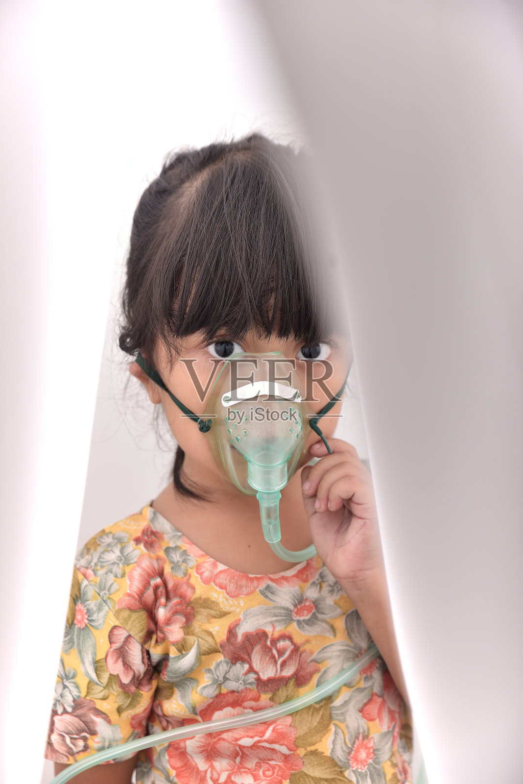 小女孩戴着喷雾器口罩，治疗病毒大流行在家隔离照片摄影图片