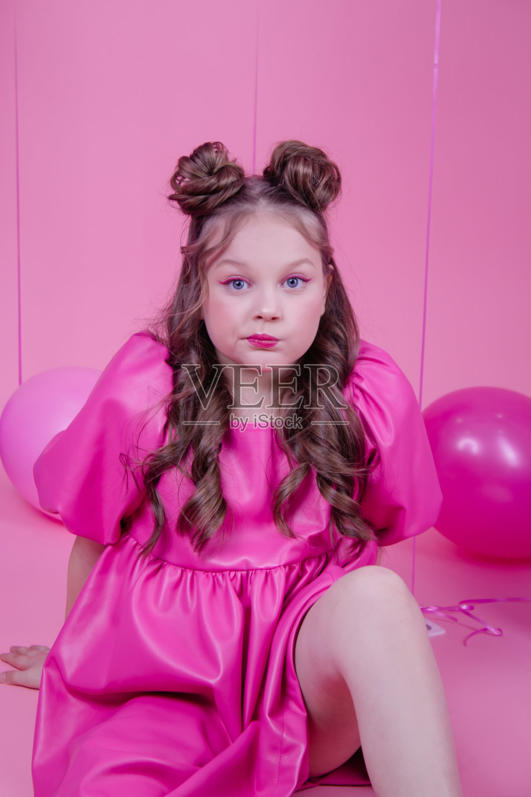 迷人的黑发女孩模型粉红色的化妆和在粉红色的皮衣附近彩色气球在粉红色的背景。欢乐的概念，聚会，生日。照片摄影图片