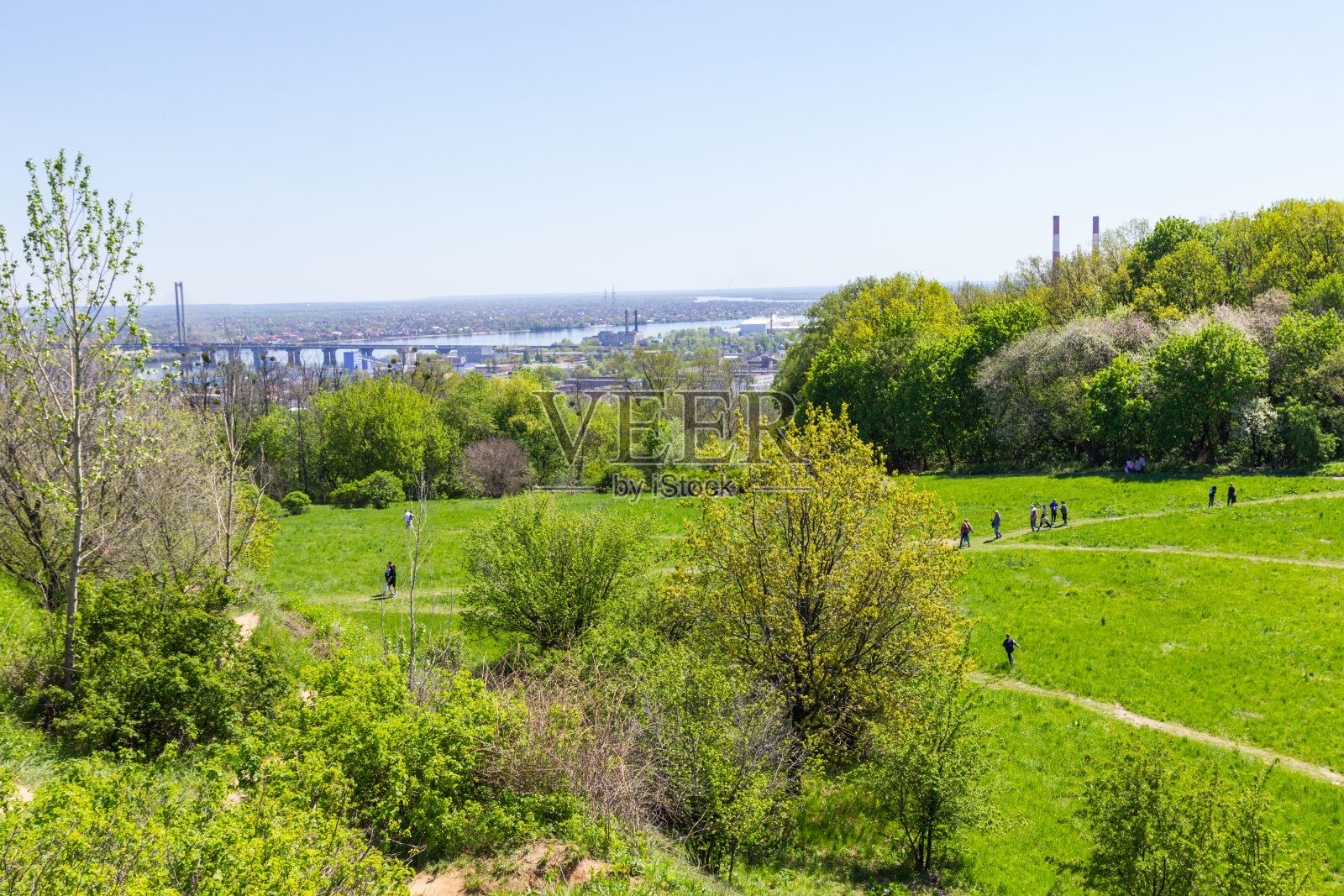 城市景观。人们在绿色的草地上散步照片摄影图片