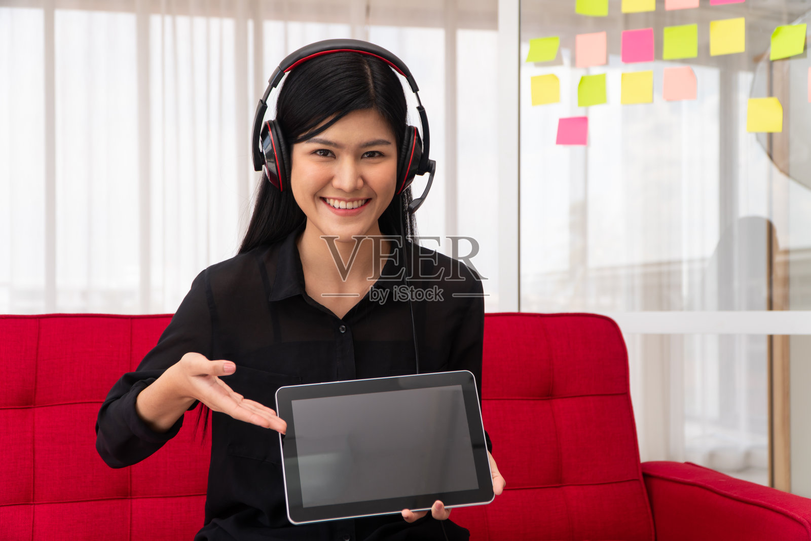 亚洲女性博客影响者坐在家里的沙发上录制视频博客教学和指导她的学生或订阅者。概念的内容创造者在线为一个新的生活方式照片摄影图片