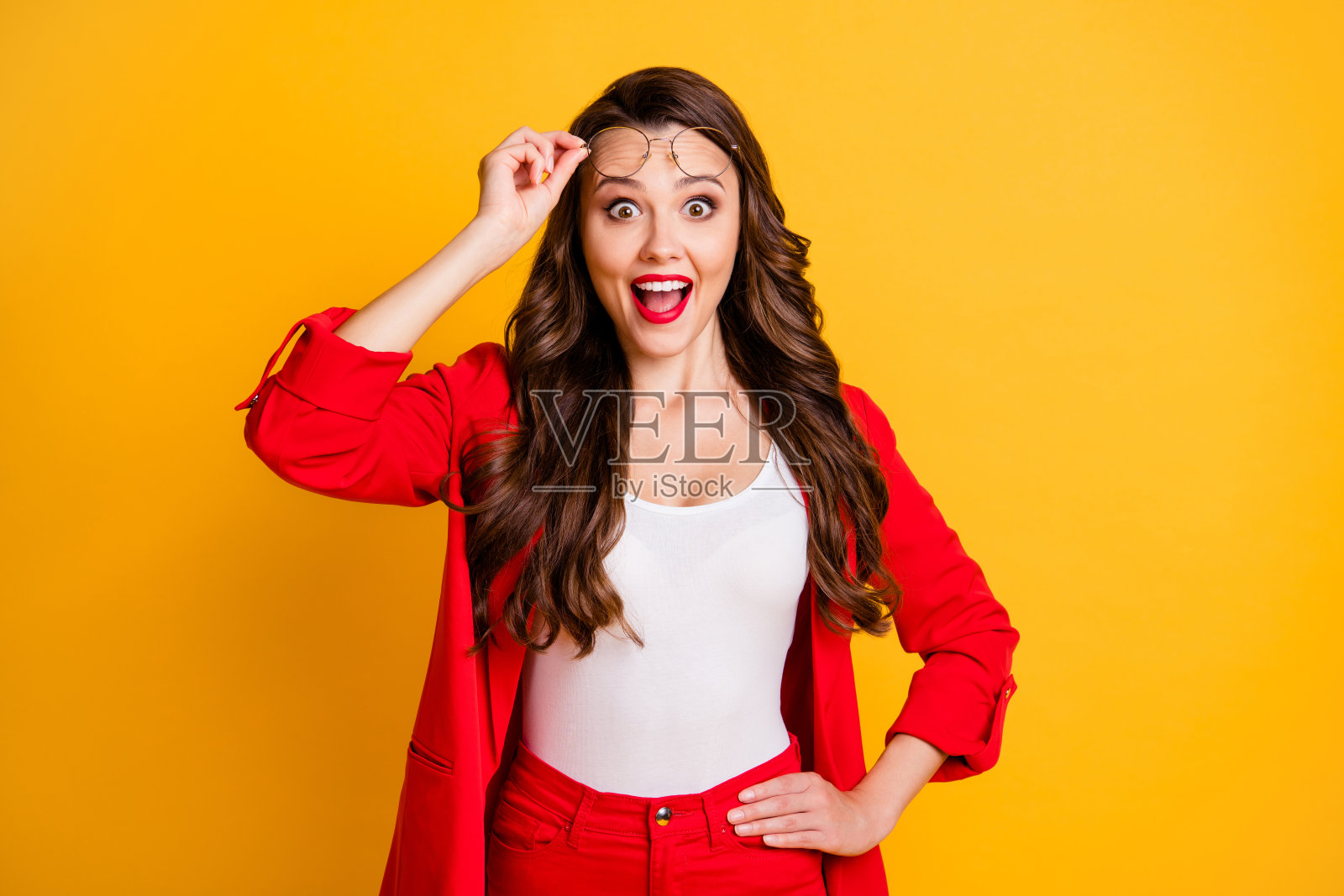 她的肖像，她漂亮的迷人的，迷人的，愉快的，惊奇的卷发女士专家，专家触摸眼镜，新闻反应孤立的，明亮的，生动的，闪亮的，充满活力的黄色背景照片摄影图片