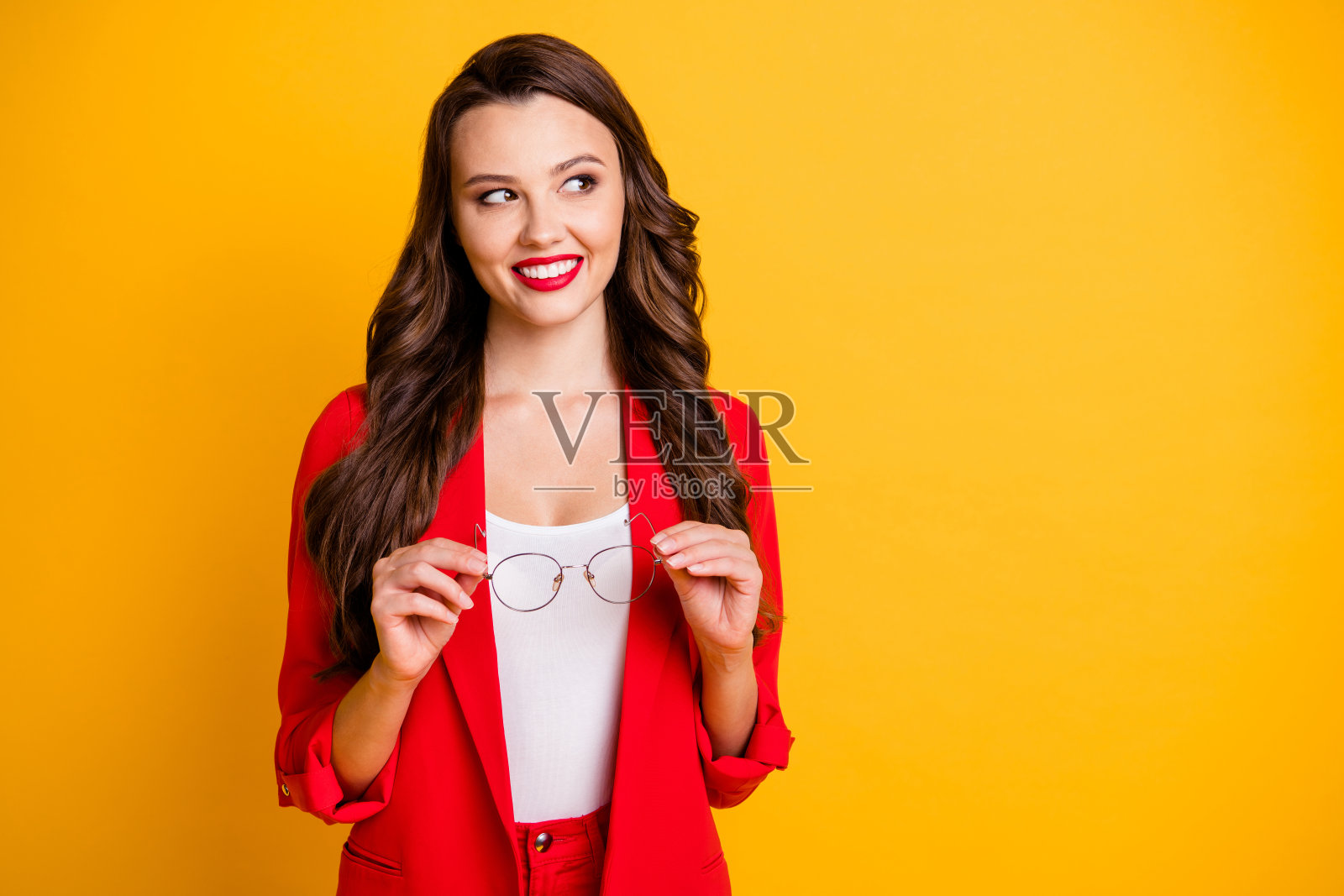 她的肖像，她漂亮迷人迷人，愉快，好奇的卷发女士专家手中拿着眼镜思考复制空间孤立在明亮生动的亮充满活力的黄色背景照片摄影图片