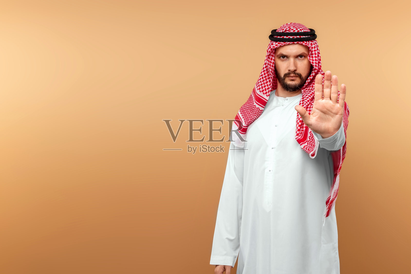 身穿民族服装的男人做出停止手势。迪什达沙，坎多拉，托布，防范冠状病毒，预防传染病。留白区域。照片摄影图片