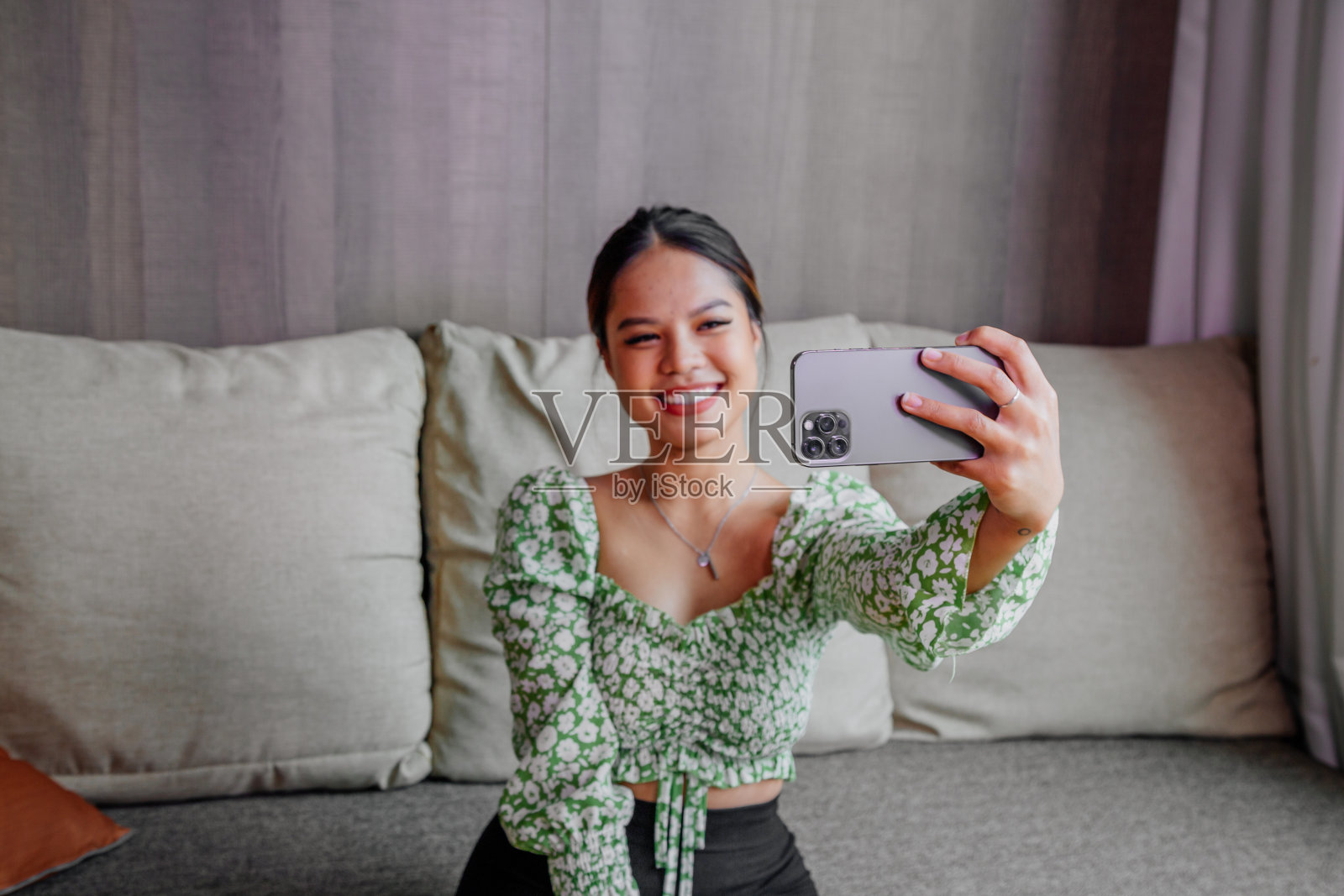 漂亮的亚洲女孩用她的智能手机自拍。泰国女孩有问题照片摄影图片