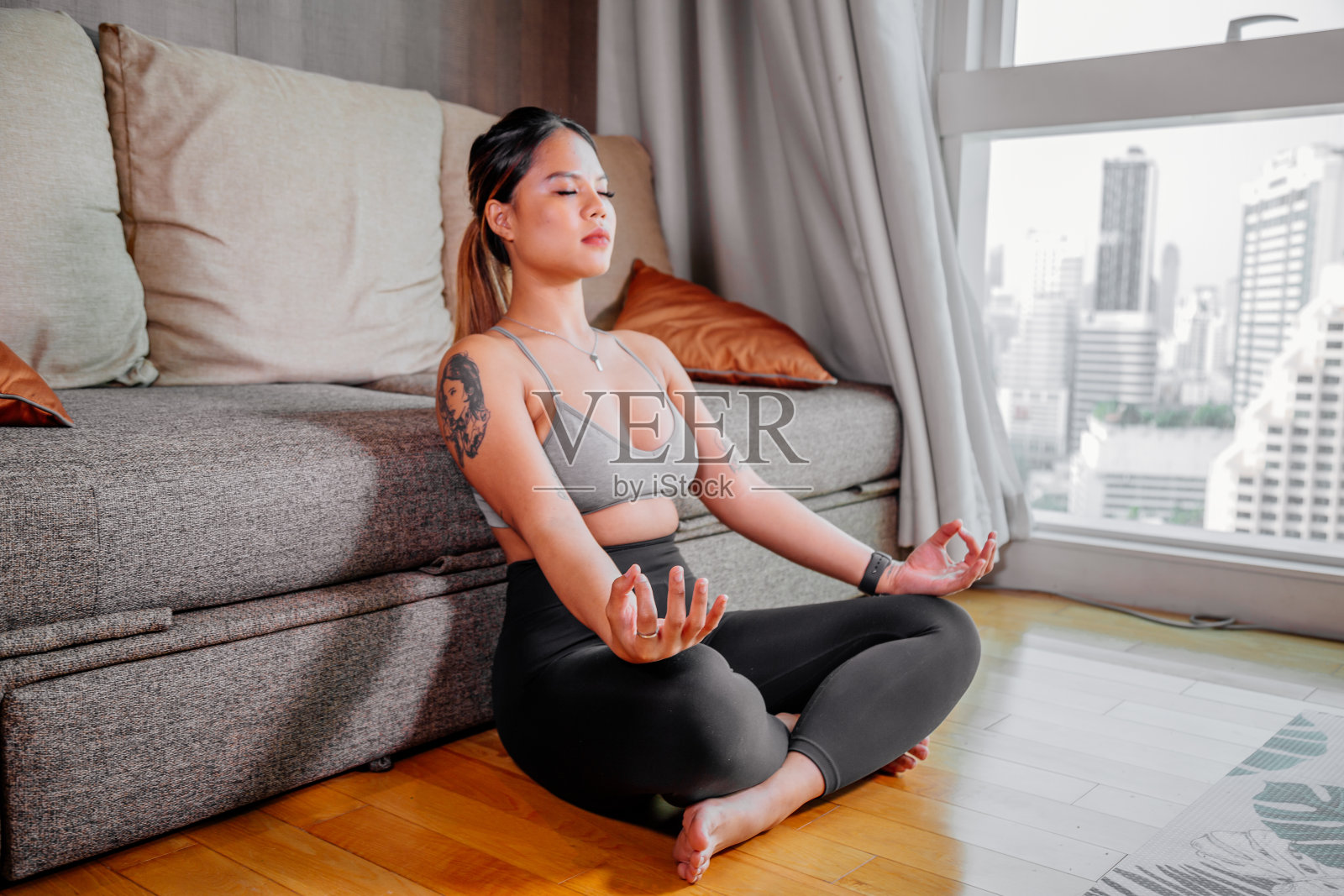 年轻的亚洲健康女性在家锻炼，看视频锻炼，健身，做瑜伽，平板支撑，腹肌，冥想。体重体操。健康的生活方式。家庭健身的概念照片摄影图片