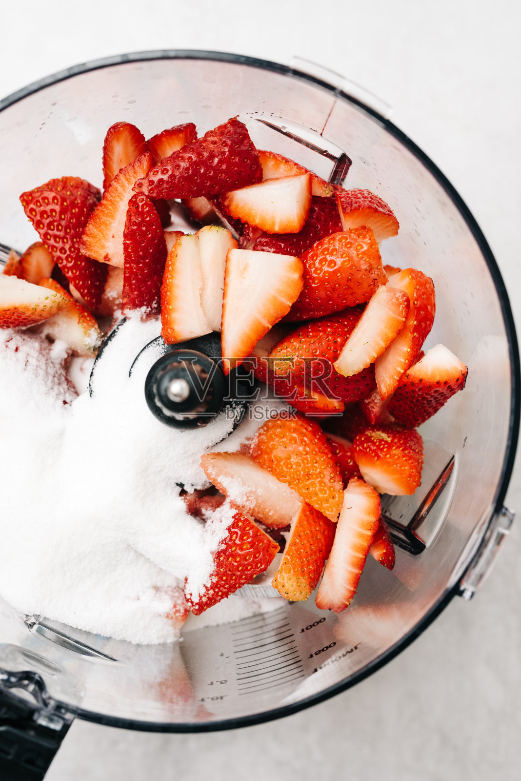 把草莓和糖放在搅拌机里照片摄影图片