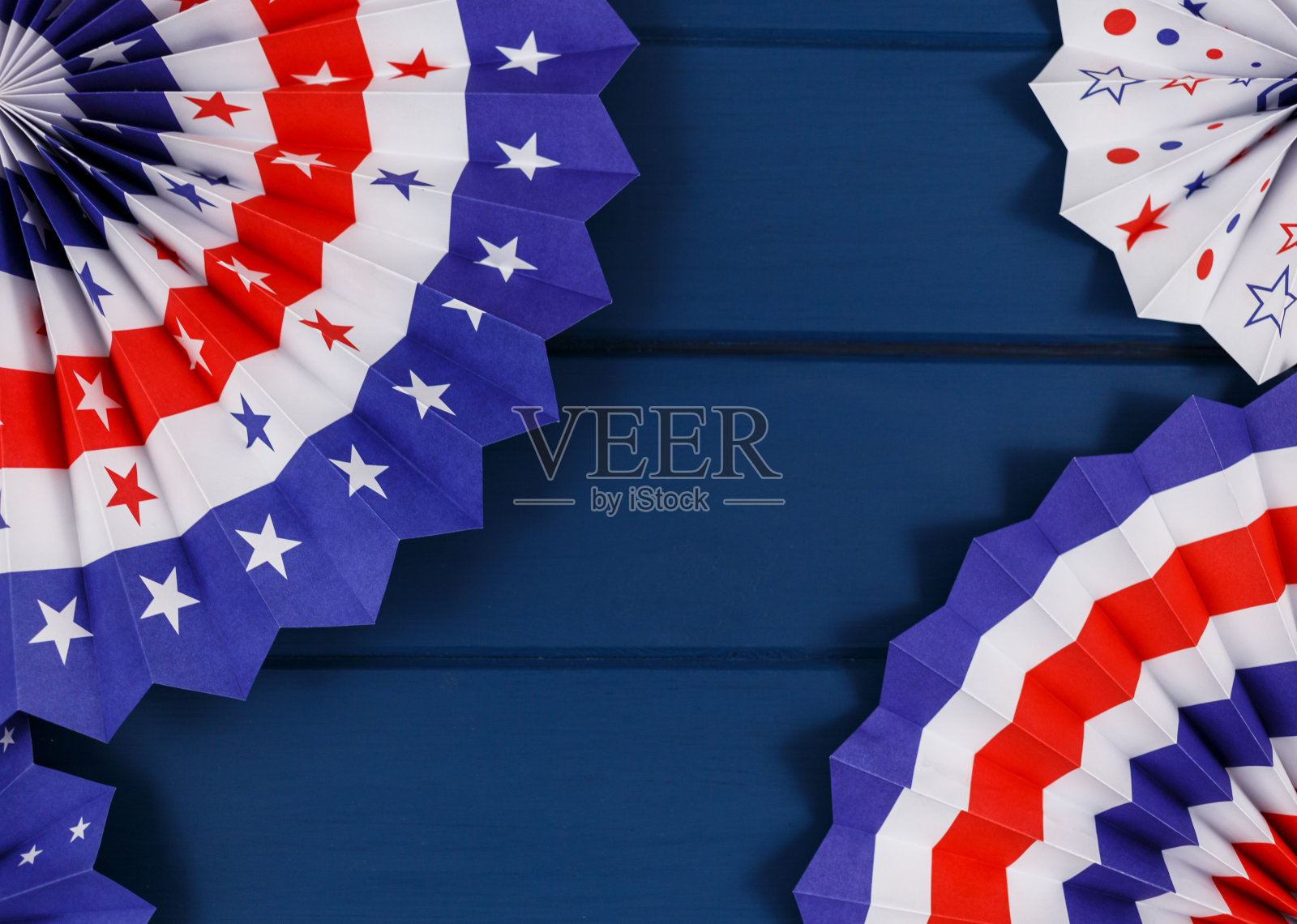 7月4日美国独立纪念日的装饰品，国旗，蜡烛，吸管，纸扇。美国节日装饰以蓝色为背景，俯视图，平铺照片摄影图片