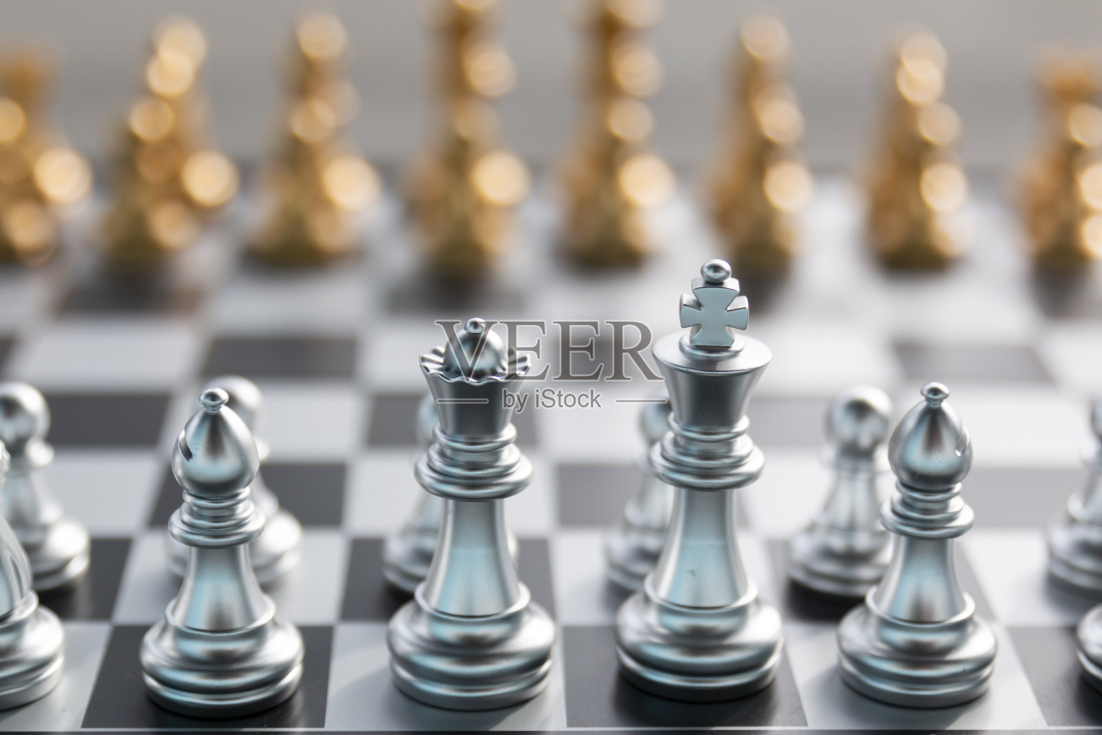 金棋和银棋围绕着多个倒下的棋子，经营策略，成功，团队理念。棋盘上的象棋。棋牌游戏，商业创意和竞争。照片摄影图片