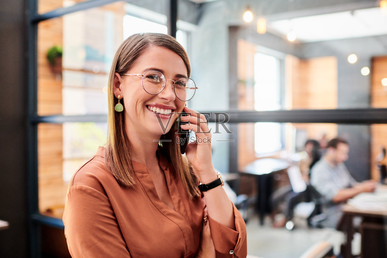 这是一个年轻的女商人在现代办公室里使用智能手机的照片照片摄影图片