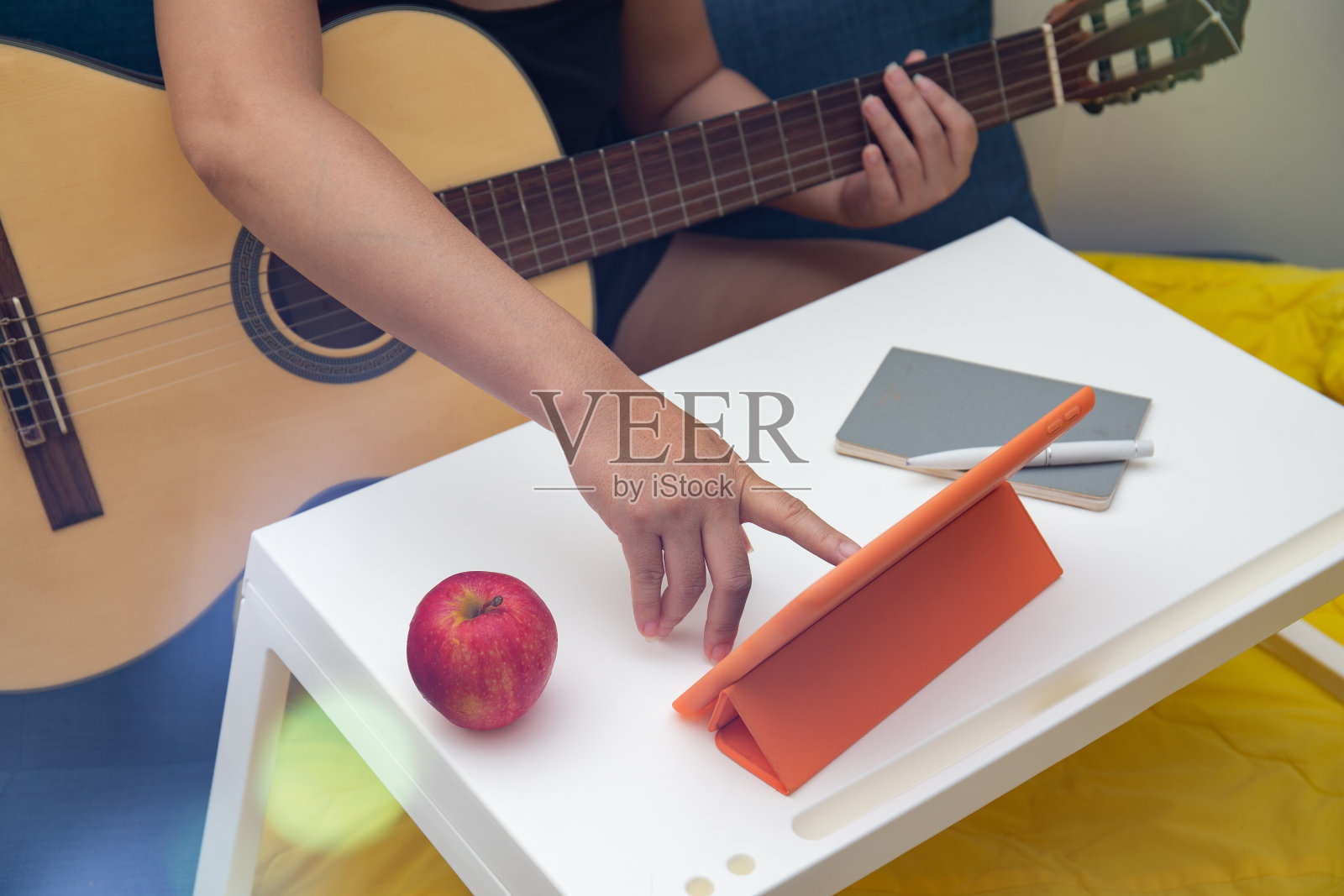 学习弹吉他的人在平板电脑上观看课程照片摄影图片