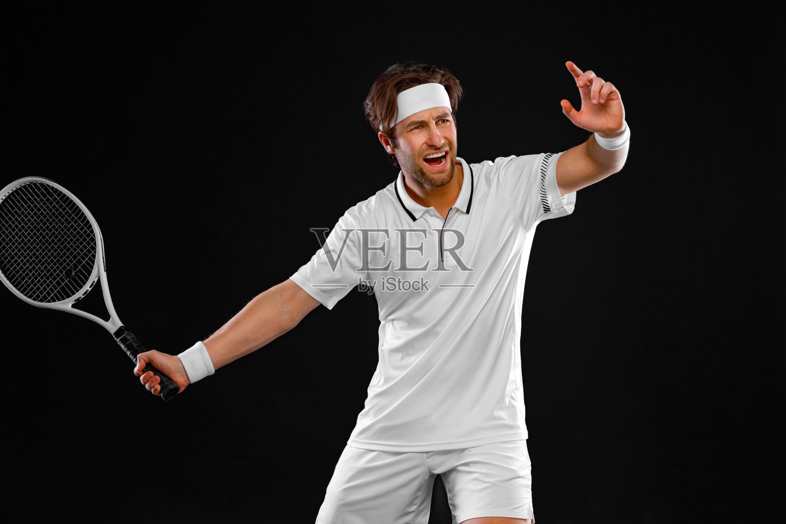 穿着白色服装带球拍的网球运动员。男子运动员玩孤立的黑色背景。照片摄影图片