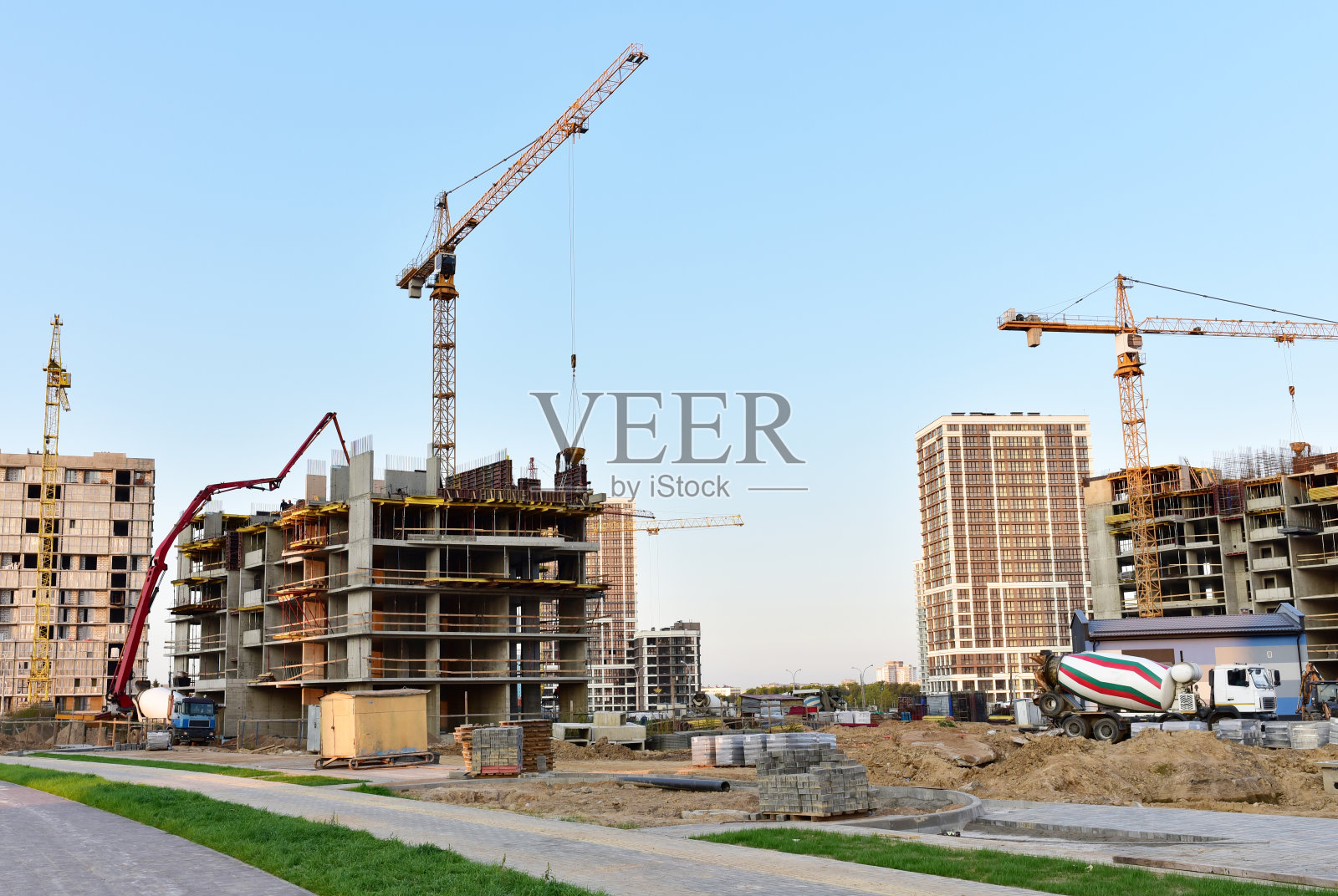 大型建筑工地视图。塔吊正在工作。模板和浇注混凝土通过混凝土泵车连接到预拌卡车照片摄影图片