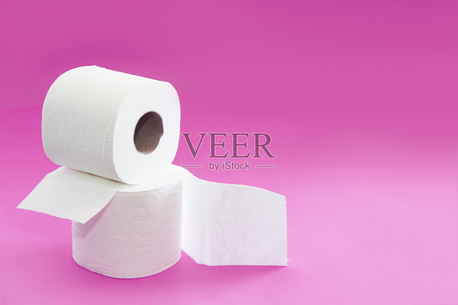 粉色背景的白色卫生纸卷照片摄影图片