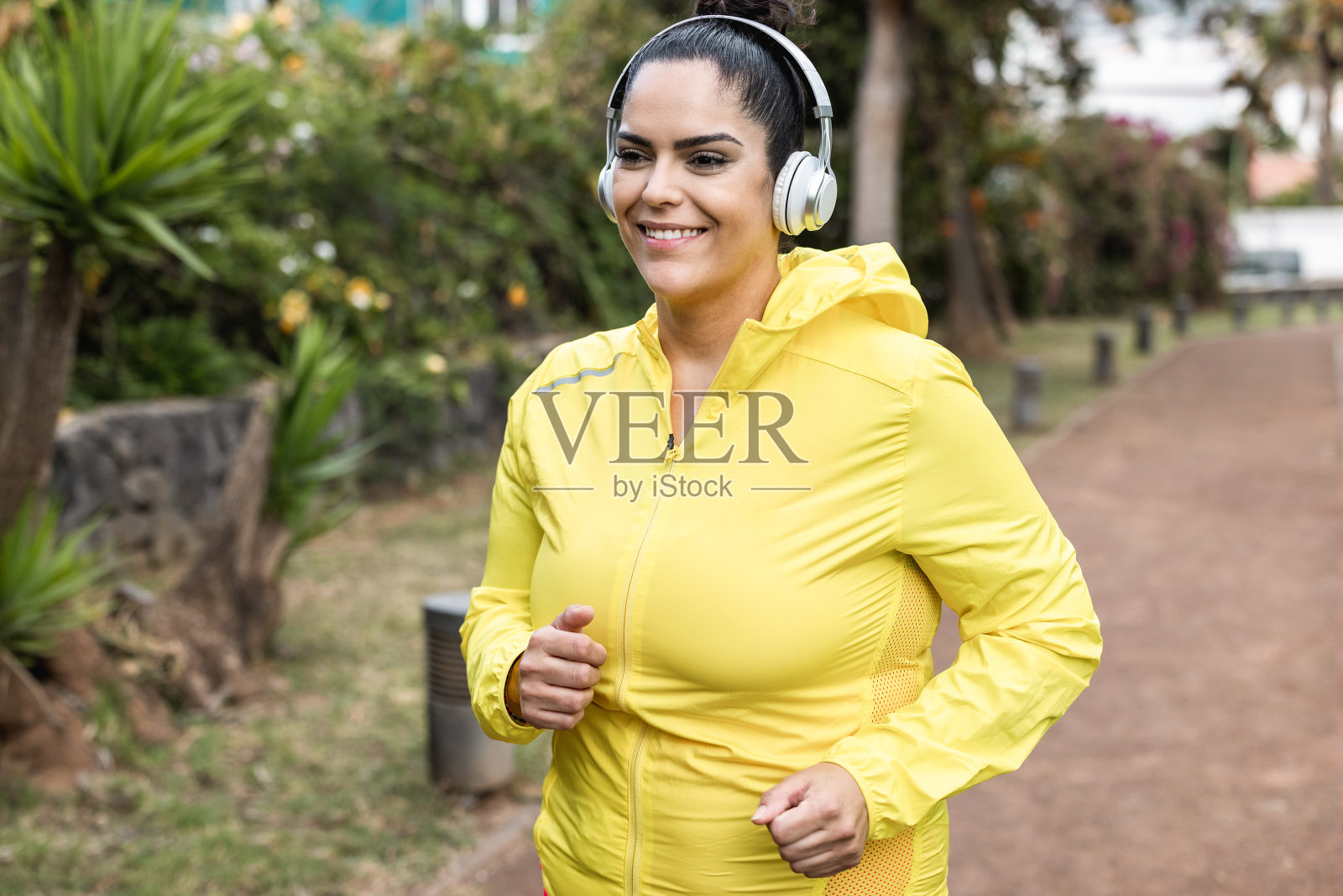 有曲线的女人在城市公园户外慢跑-加大尺寸和锻炼的概念照片摄影图片