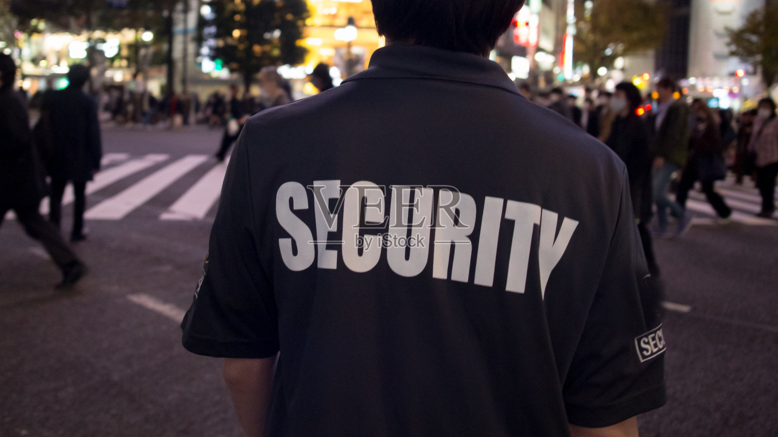 保安在晚上穿过大城市的街道。照片摄影图片