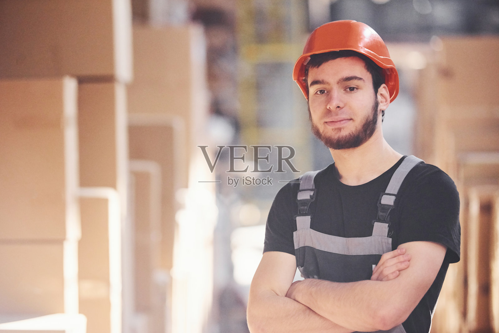 身着制服、头戴安全帽的年轻仓库工人的肖像照片摄影图片