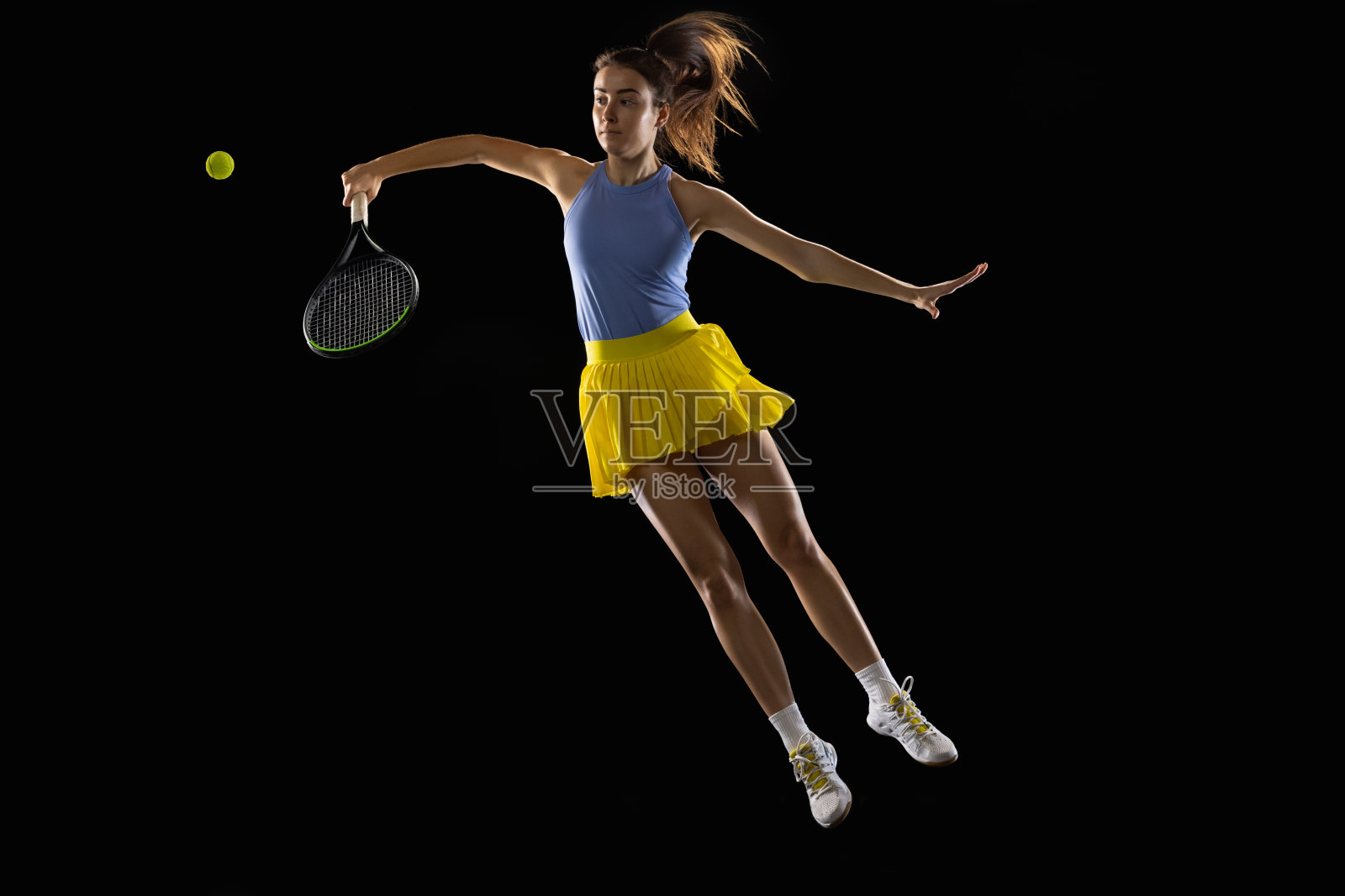 年轻的白人女子打网球孤立的黑人工作室背景在行动和运动，运动概念照片摄影图片