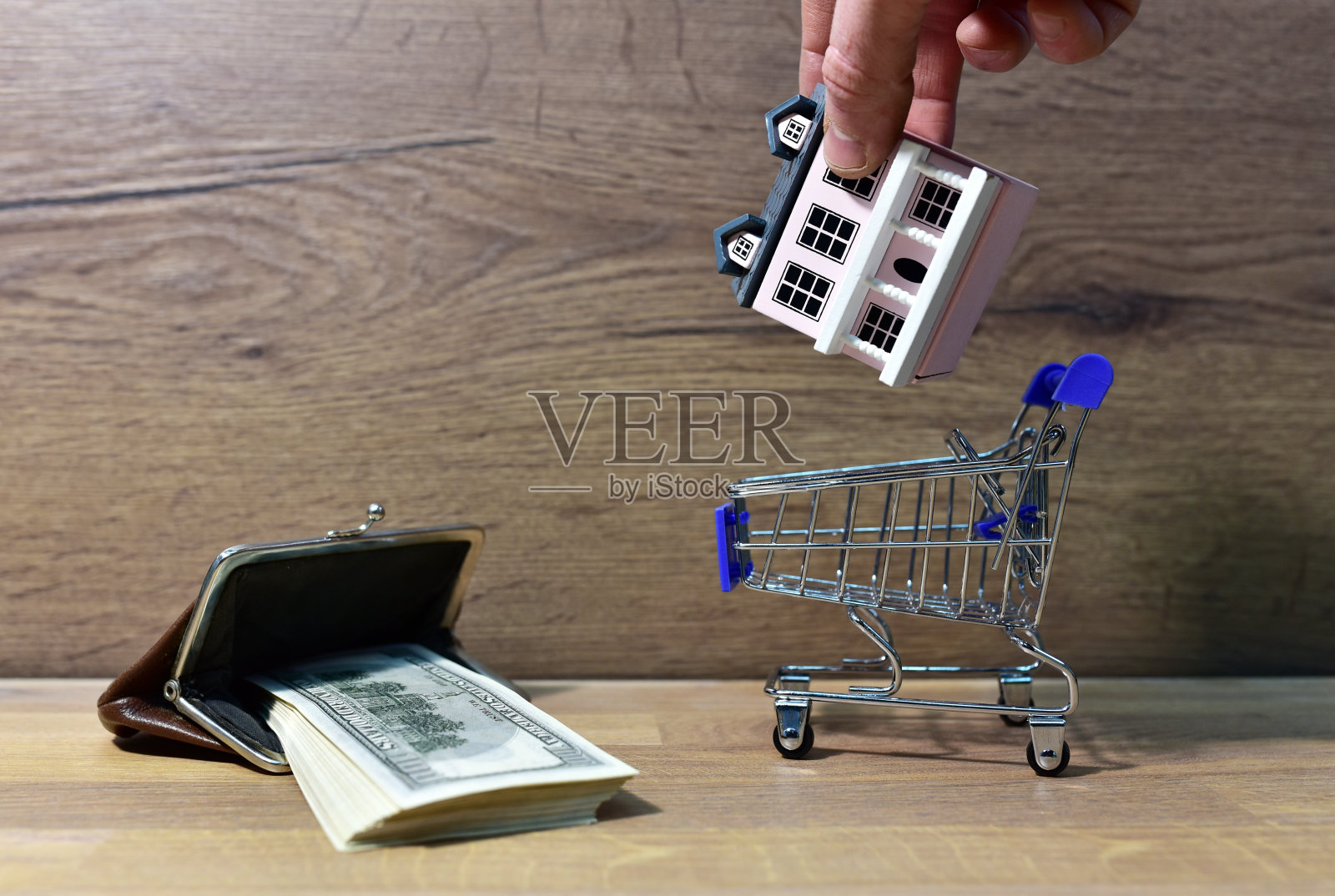 超市里的房子，手推车和钱包里装着美元。照片摄影图片