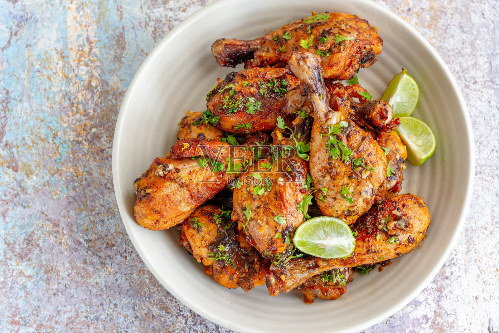 烤鸡腿放在碗里，配上柠檬和香菜照片摄影图片