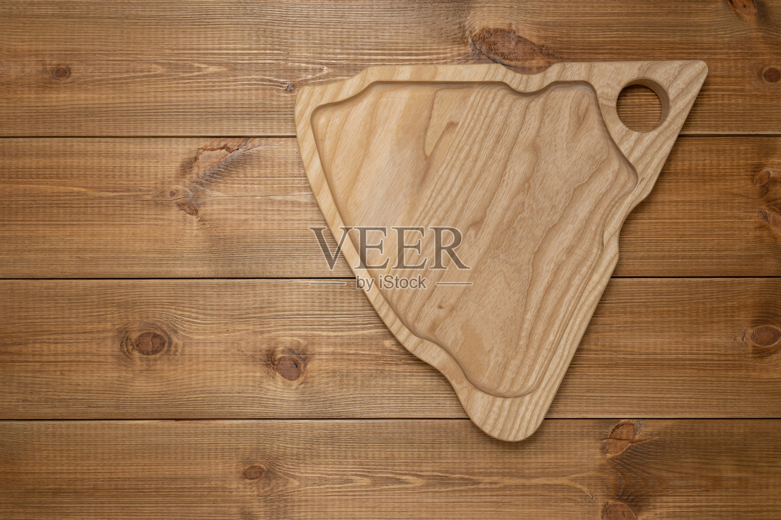 用于奶酪的装饰木盘放在木桌上，俯视图。照片摄影图片