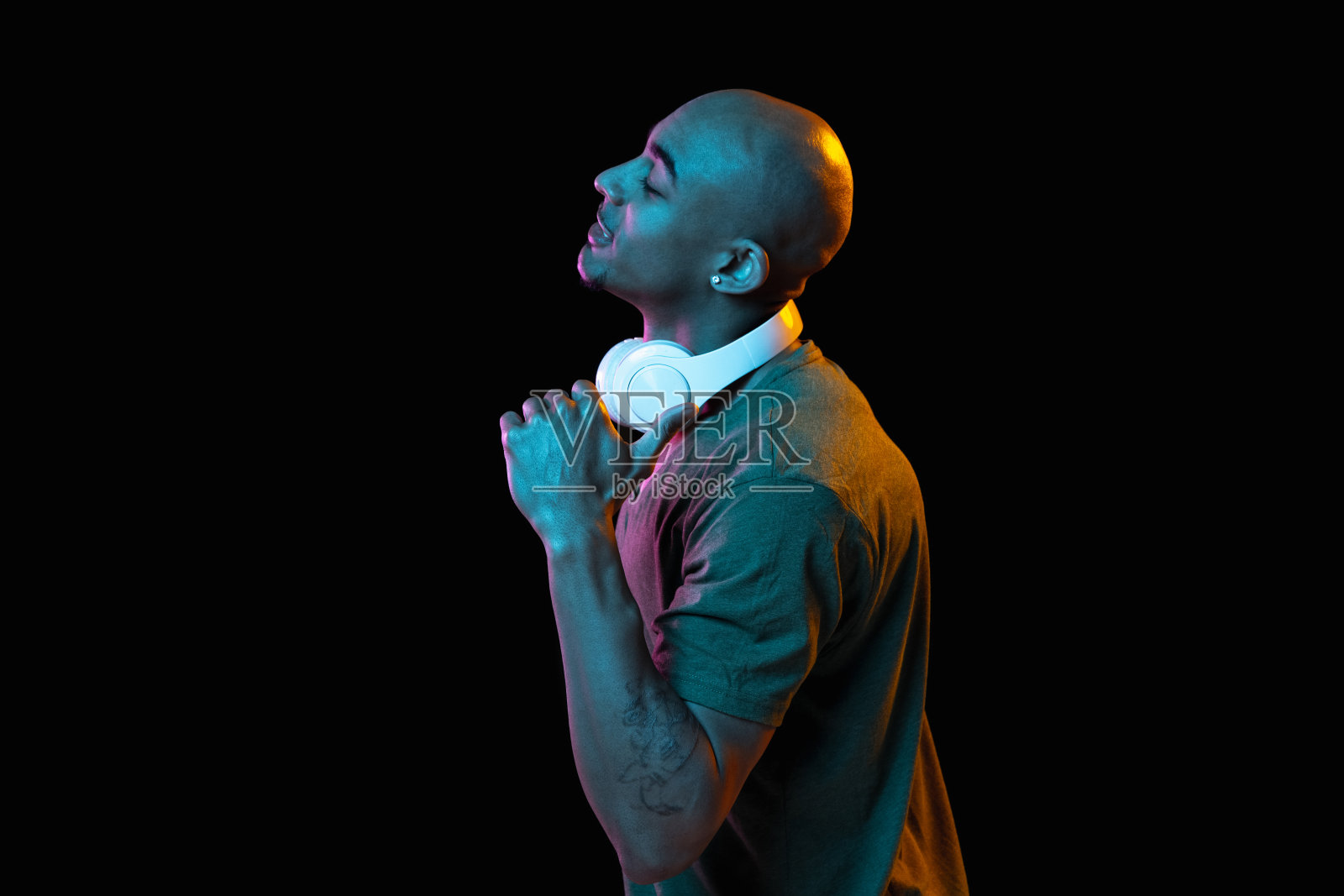 一个非洲裔美国年轻人的肖像，背景是霓虹灯。人的情感、面部表情、青春、销售、广告的概念。照片摄影图片