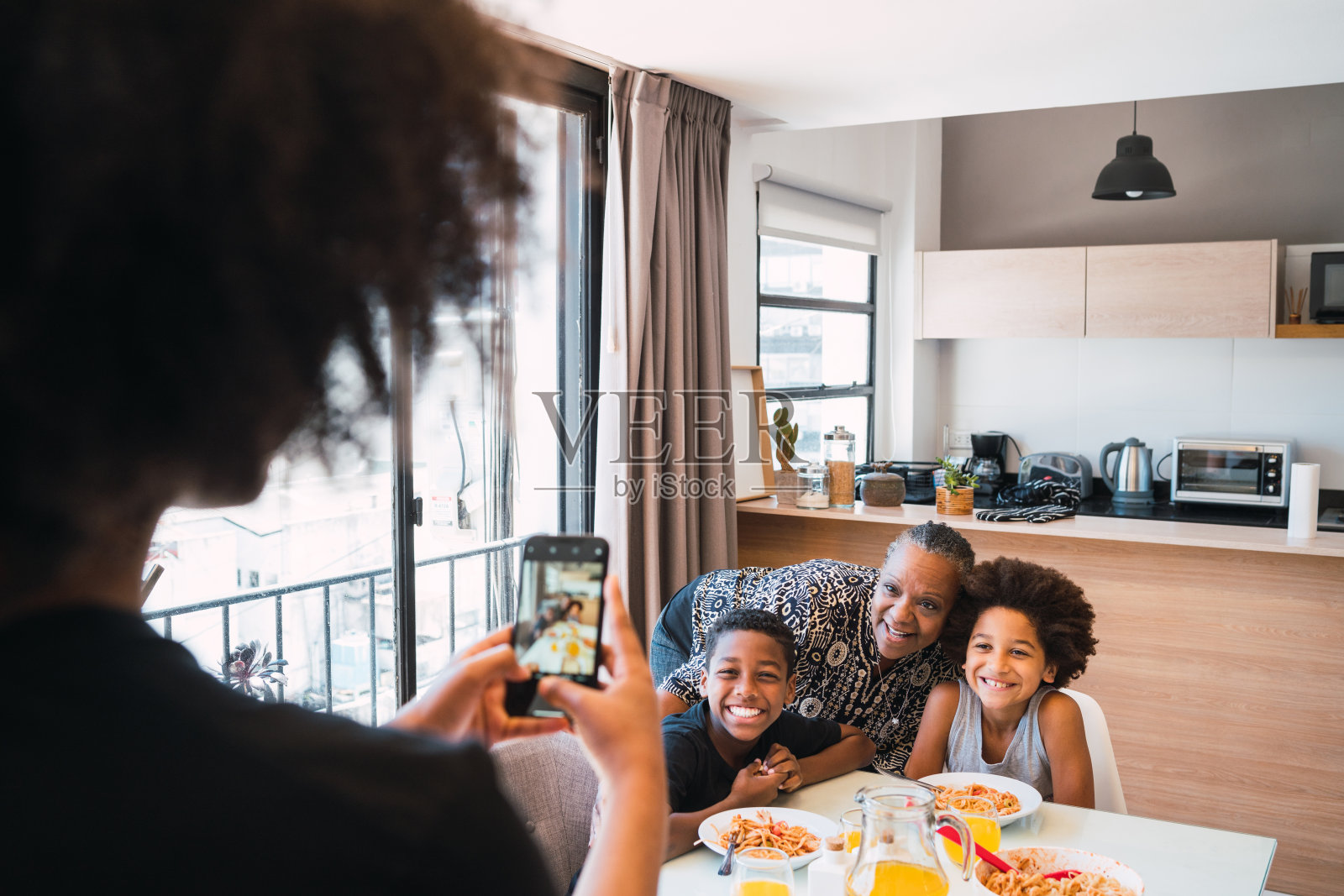 妈妈在给奶奶和孙辈拍照。照片摄影图片